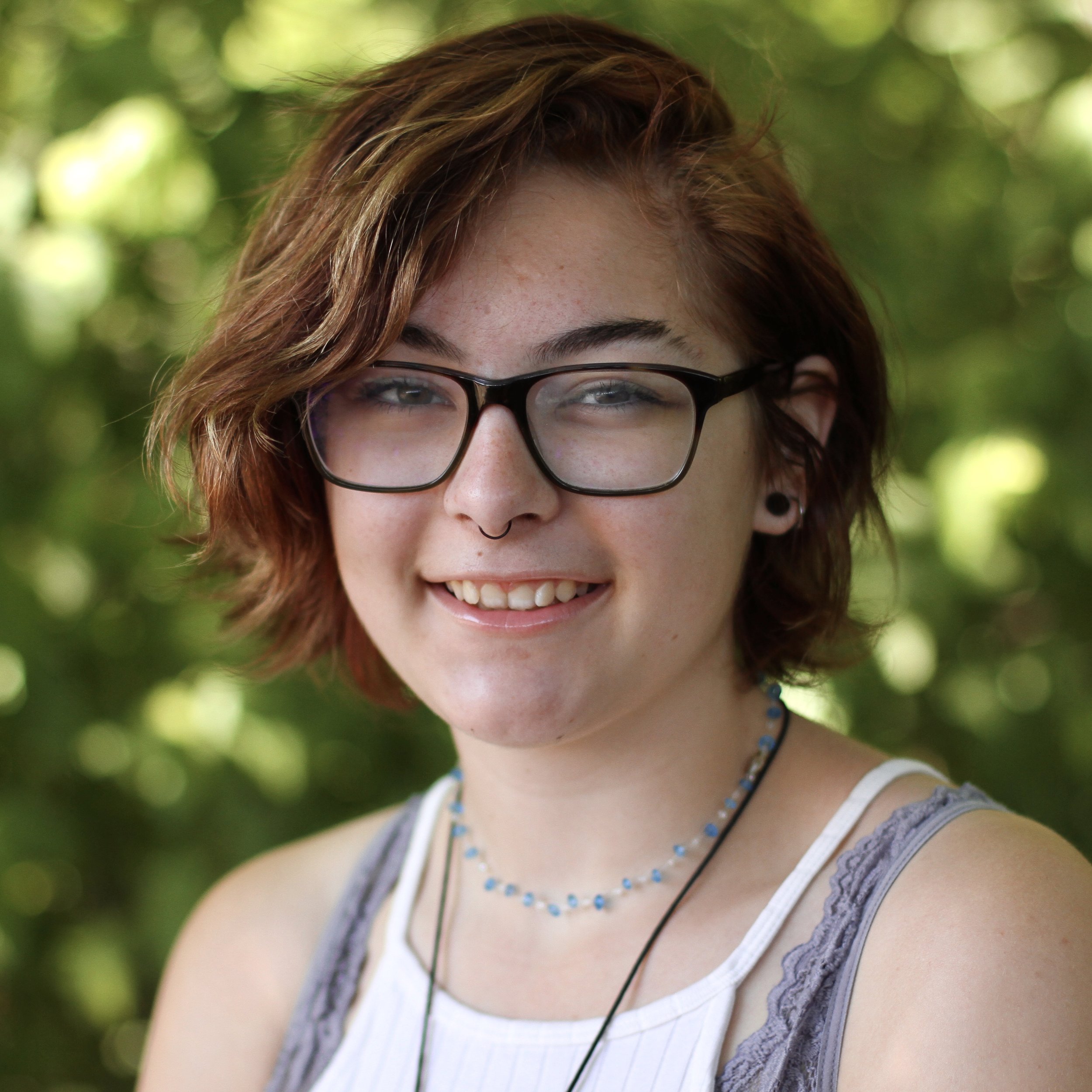 Smiling student with short red hair and glasses