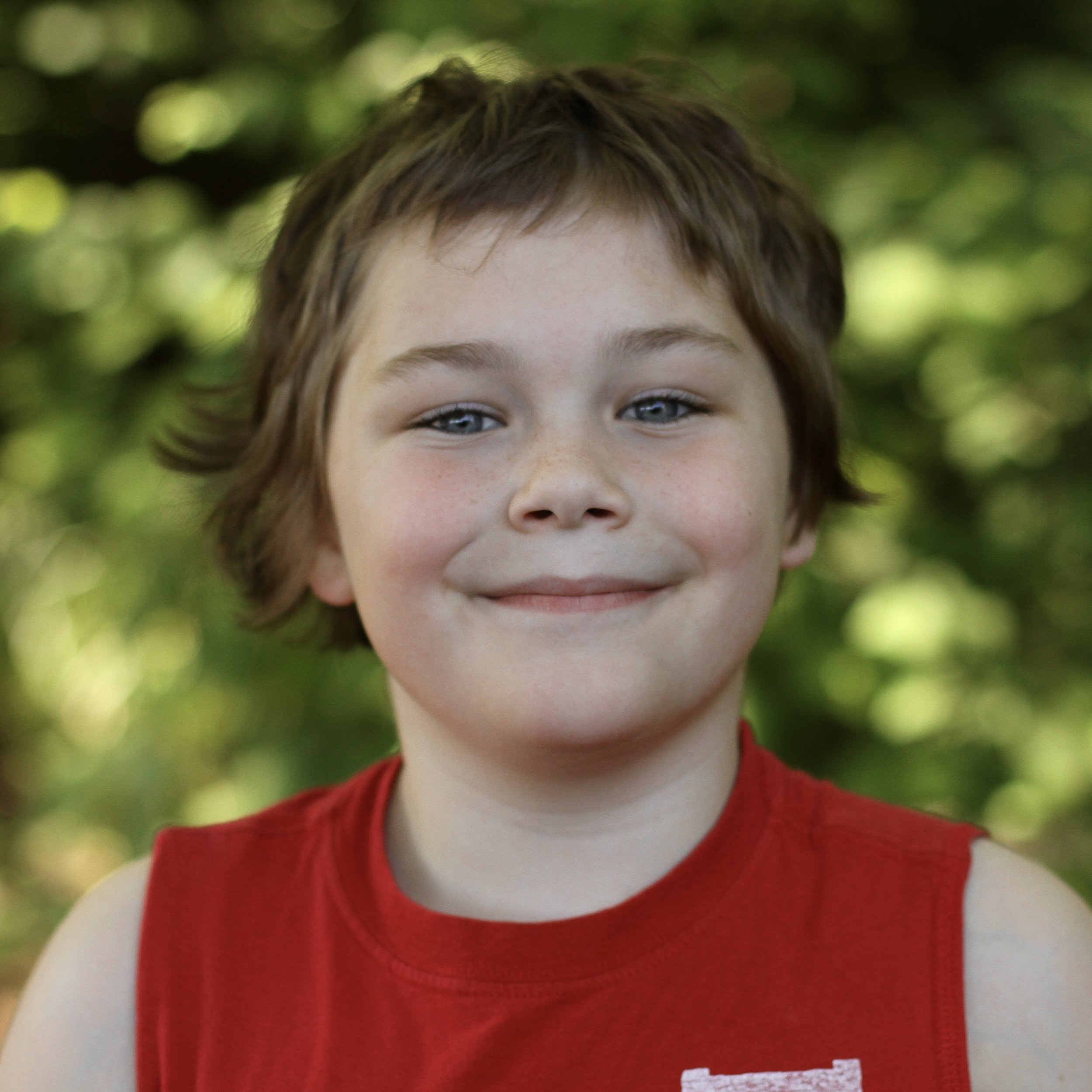 Young student smiling with short blond hair