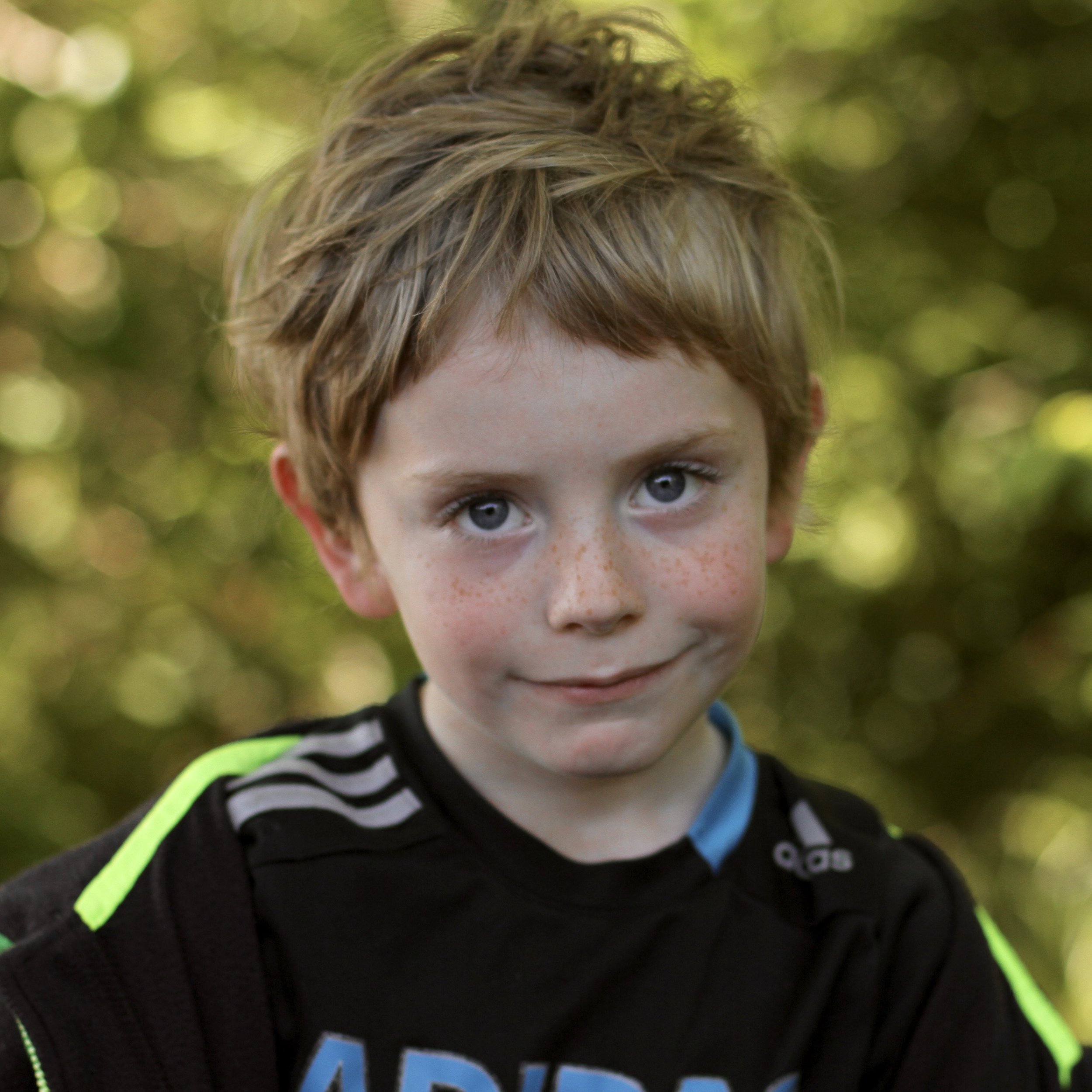 Young student smiling with short blond hair