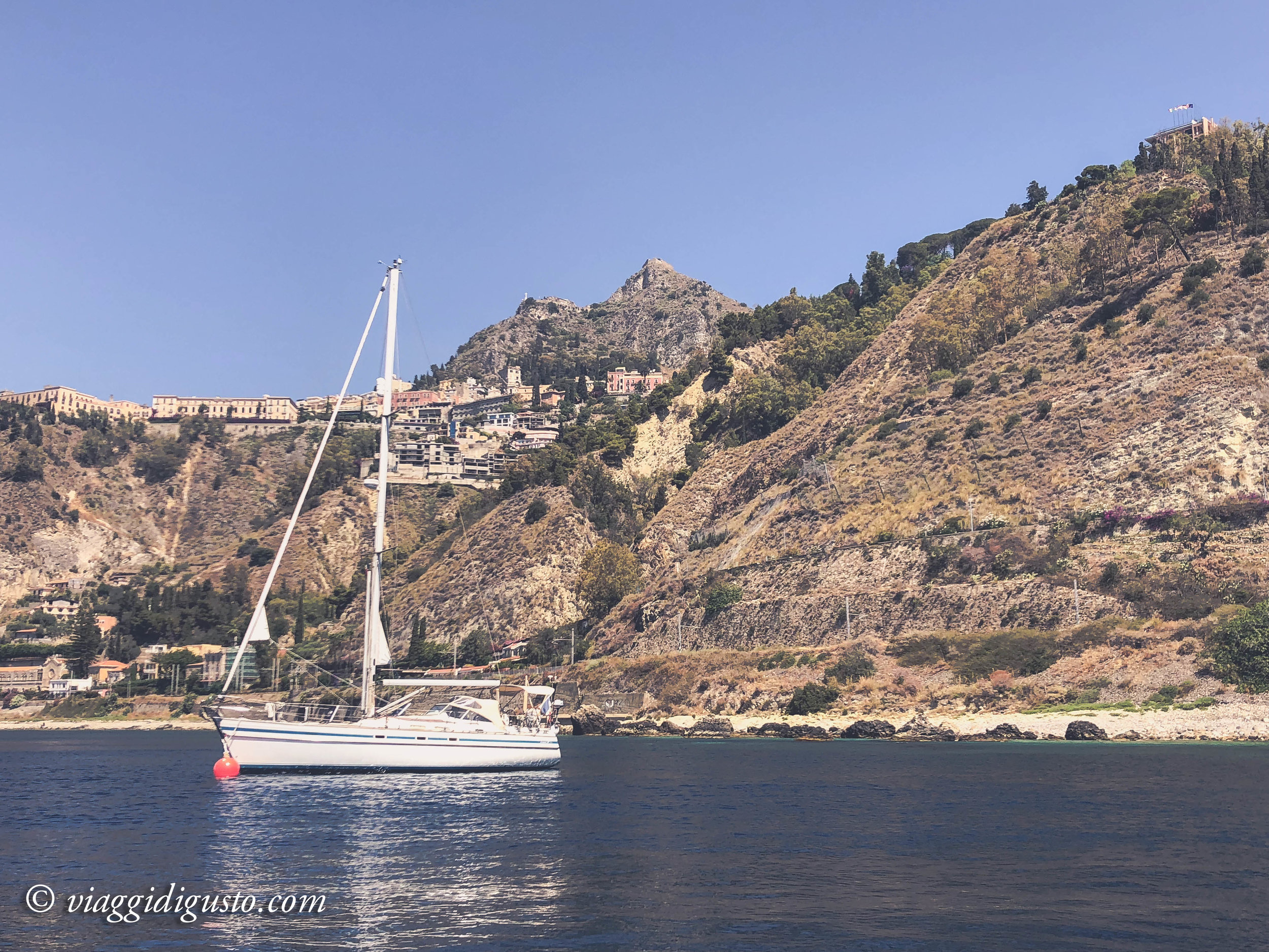Exploring the Sicilian coastline and Isola Bella by boat.