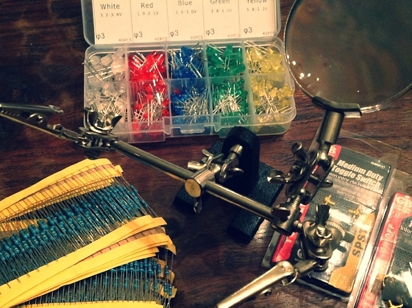 Resistors, LEDs, toggle switches, and a nifty magnifying contraption to see what the hell I'm doing.