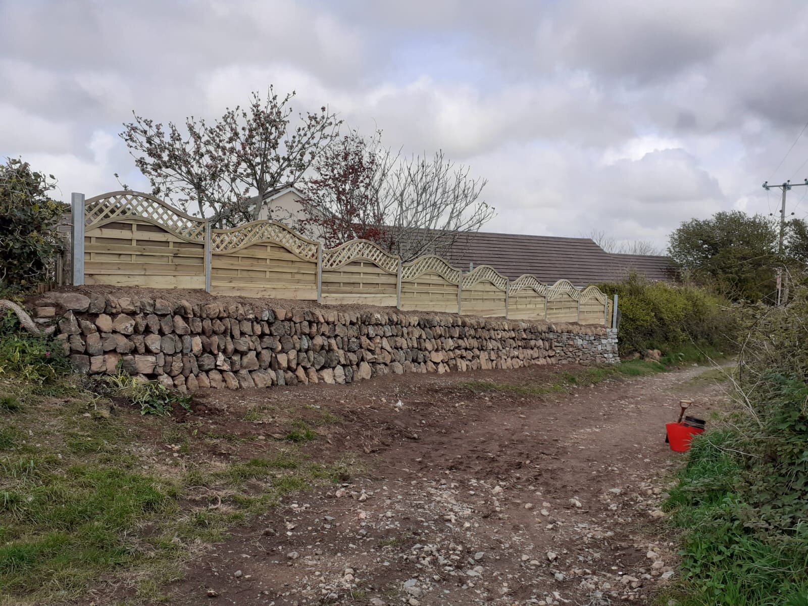 Coursed wall with fence on top