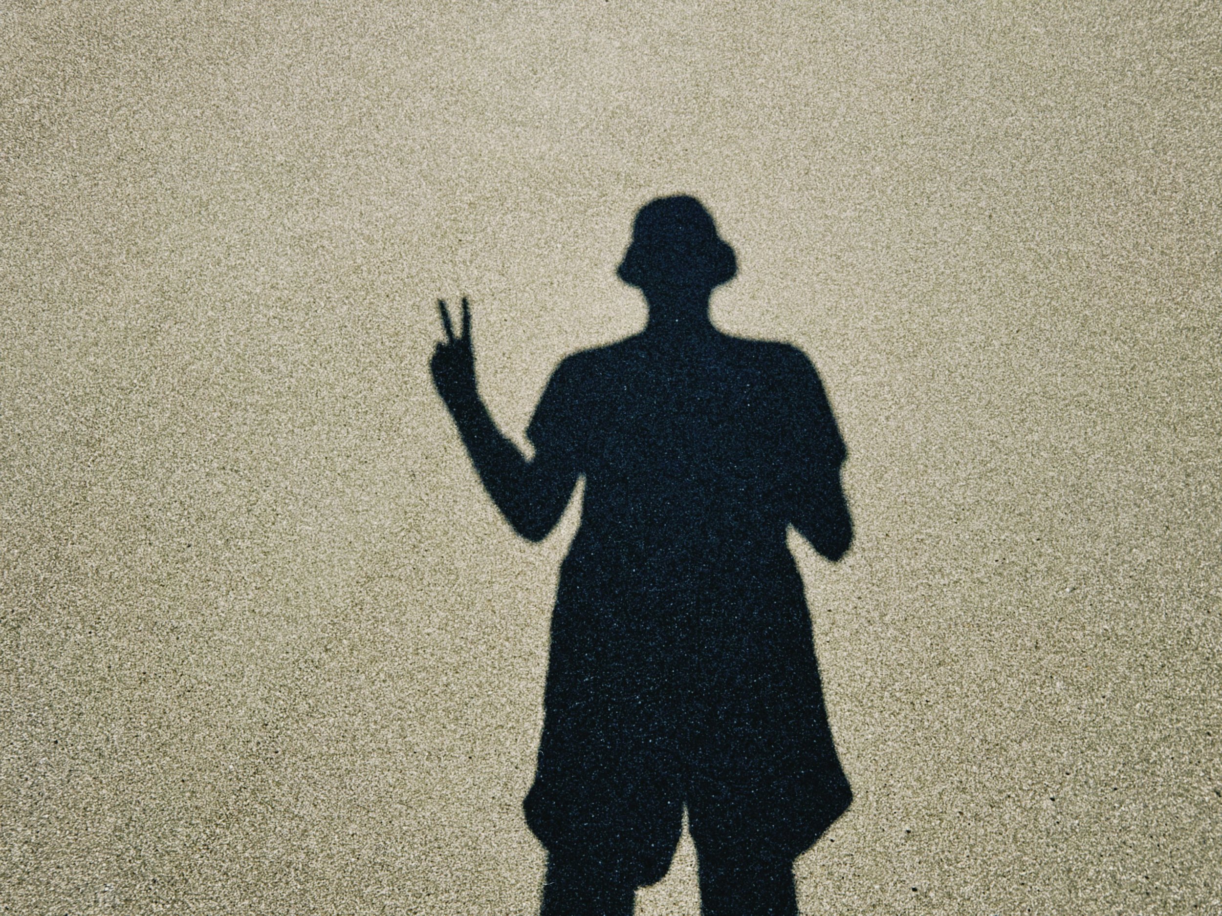 shadow of person showing peace sign