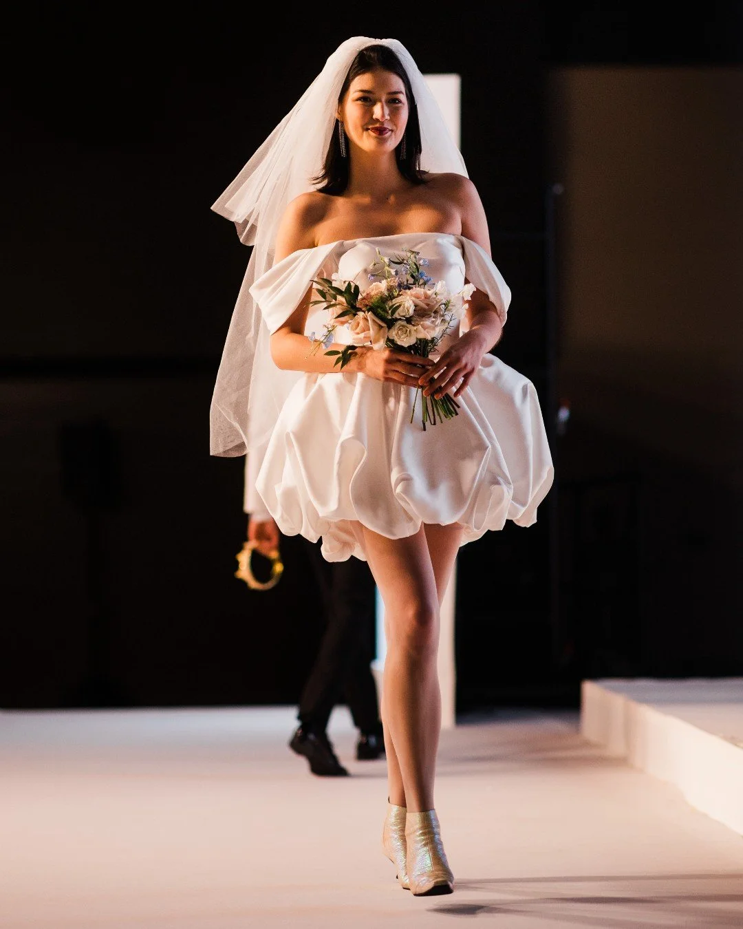 Short Dress, Big Moment.

This mini made major impact on the 2026 Seattle Wedding Show runway &mdash; bold, modern, and totally ceremony-worthy. From the off-shoulder neckline to the sculptural bubble hem, it&rsquo;s proof that short dresses can stil
