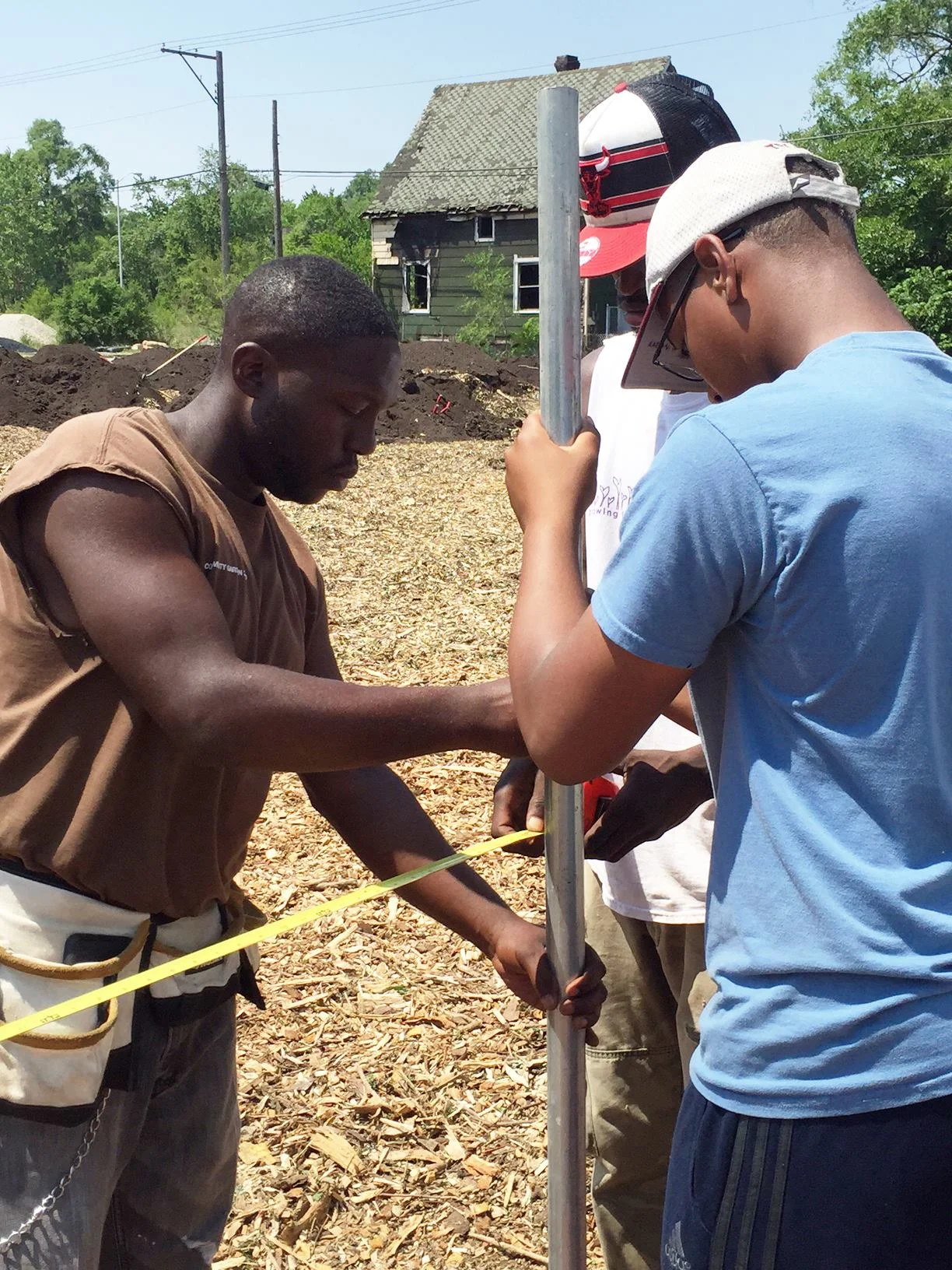 Growing Power staff and community volunteer work together to install posts