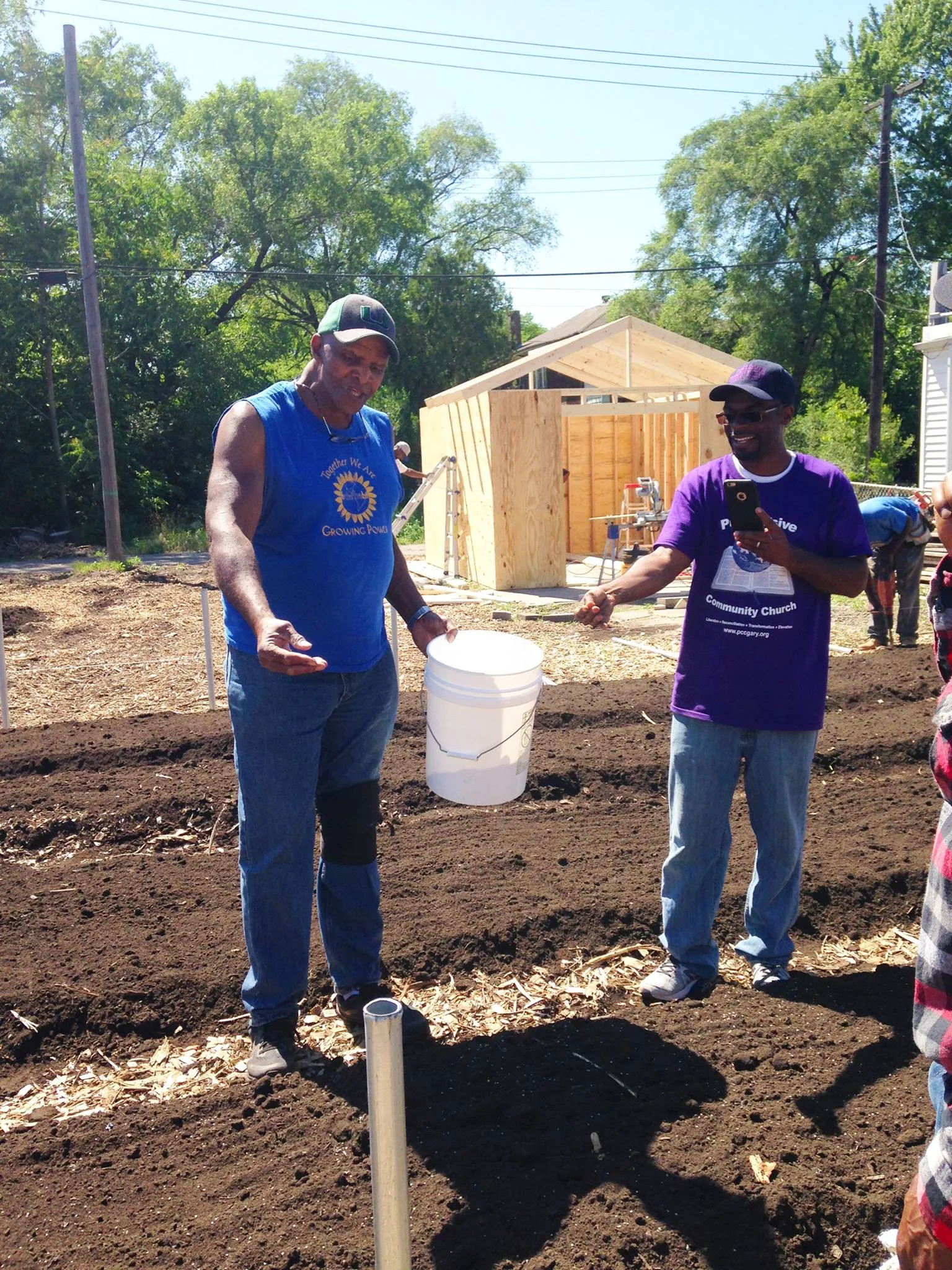 Will Allen demonstrates hand-sowing seeds with Pastor Curtis Whittaker