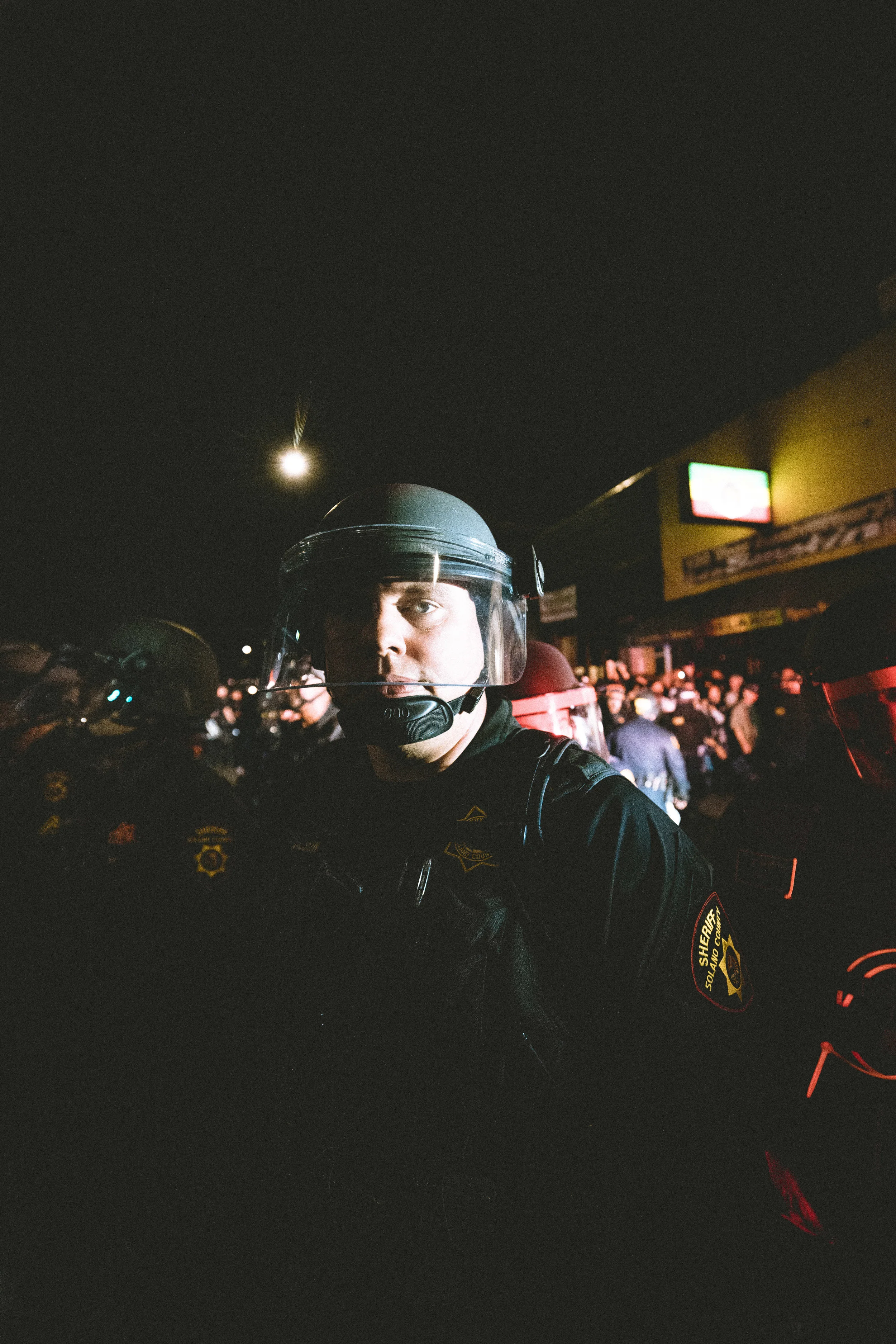 The police maintain the crowd as an ambulance is called to the scene.