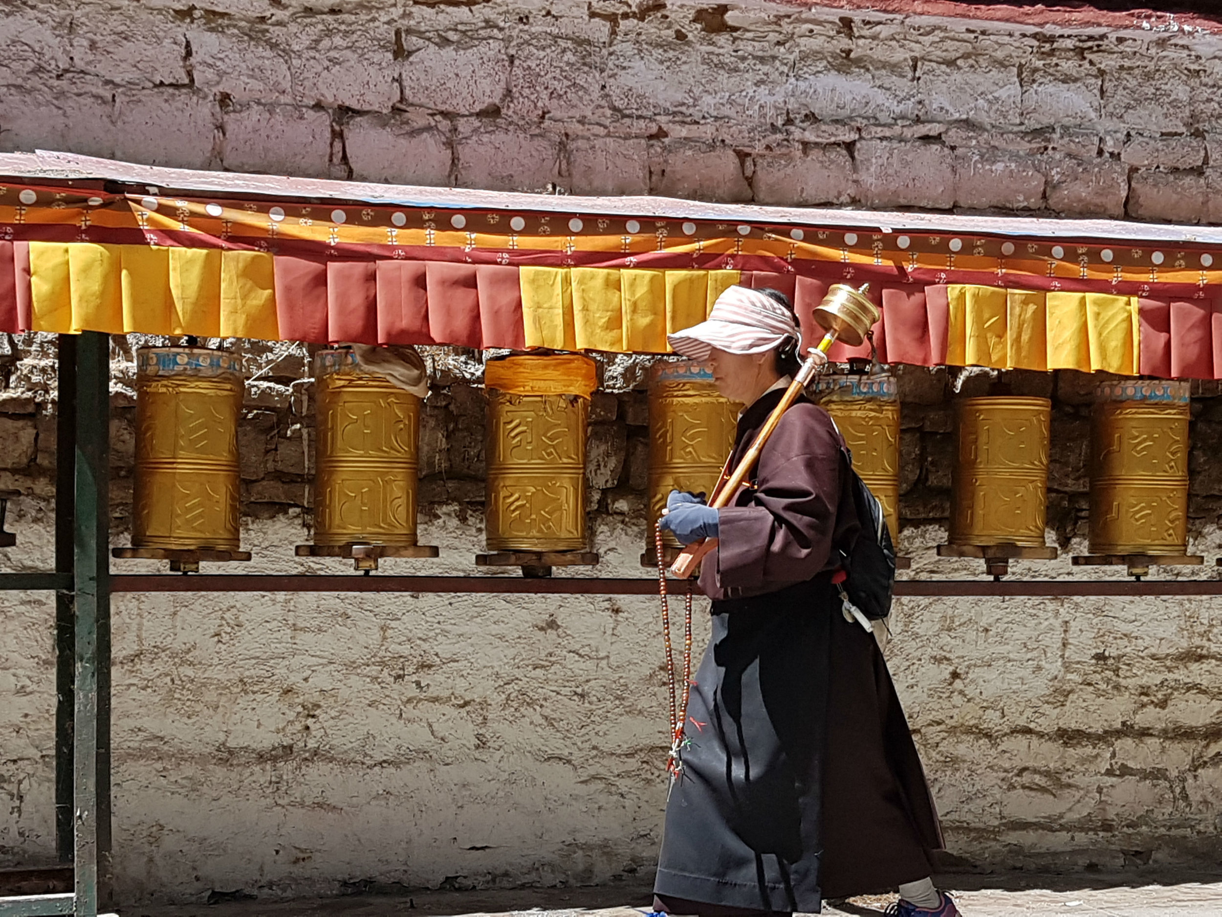Pilgrim turning prayer drums during a Kora