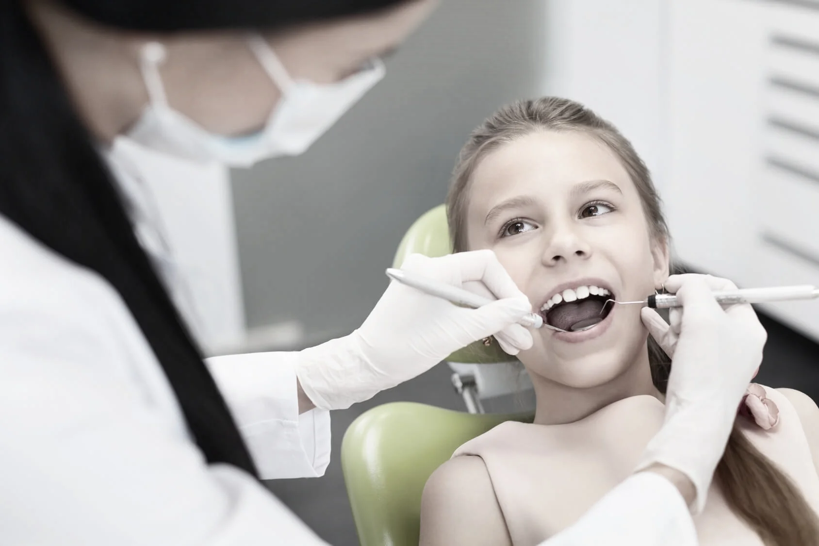 Girl smiling in the dentist chair as she has her regular child dental check-up