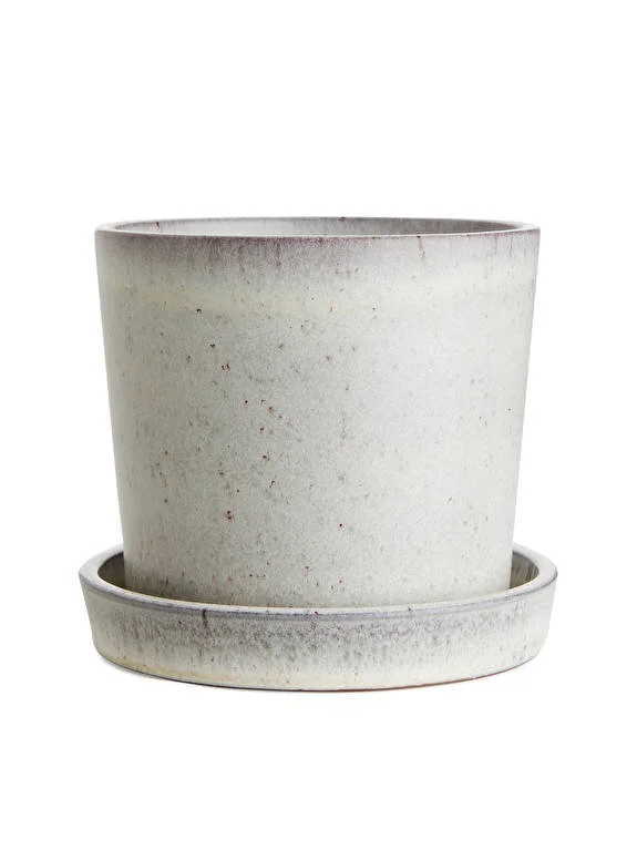 A flower pot made of terracotta with a matching saucer.