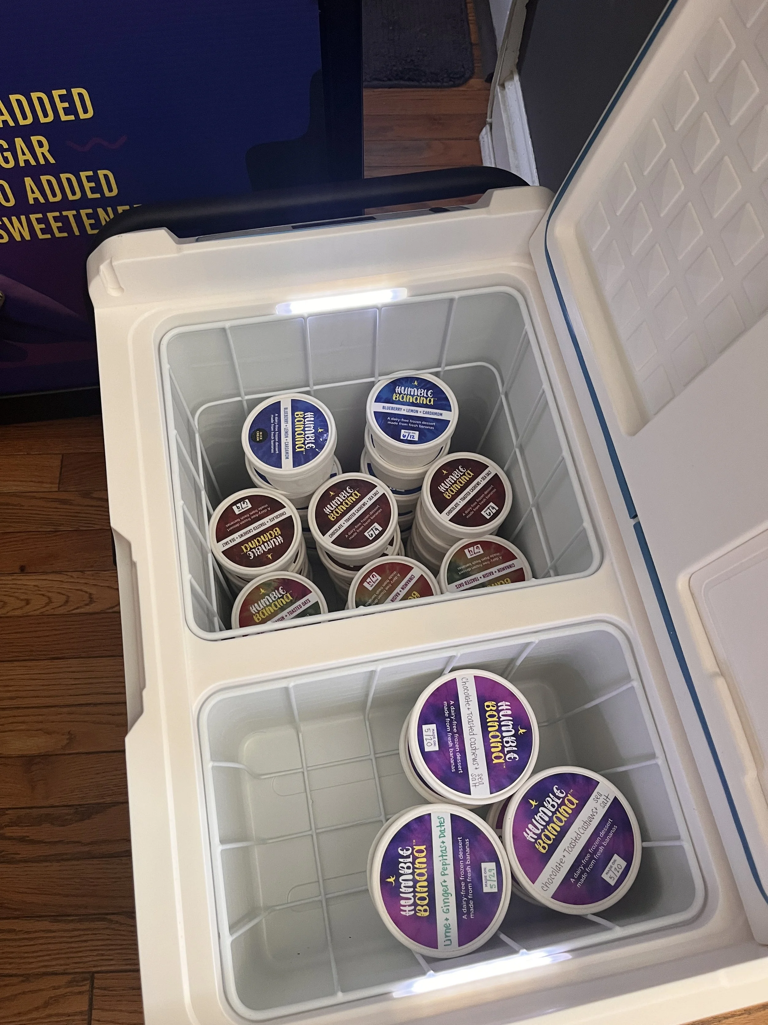 An open chest freezer containing several containers of Humble Banana frozen dessert in various flavors including chocolate and blueberry.