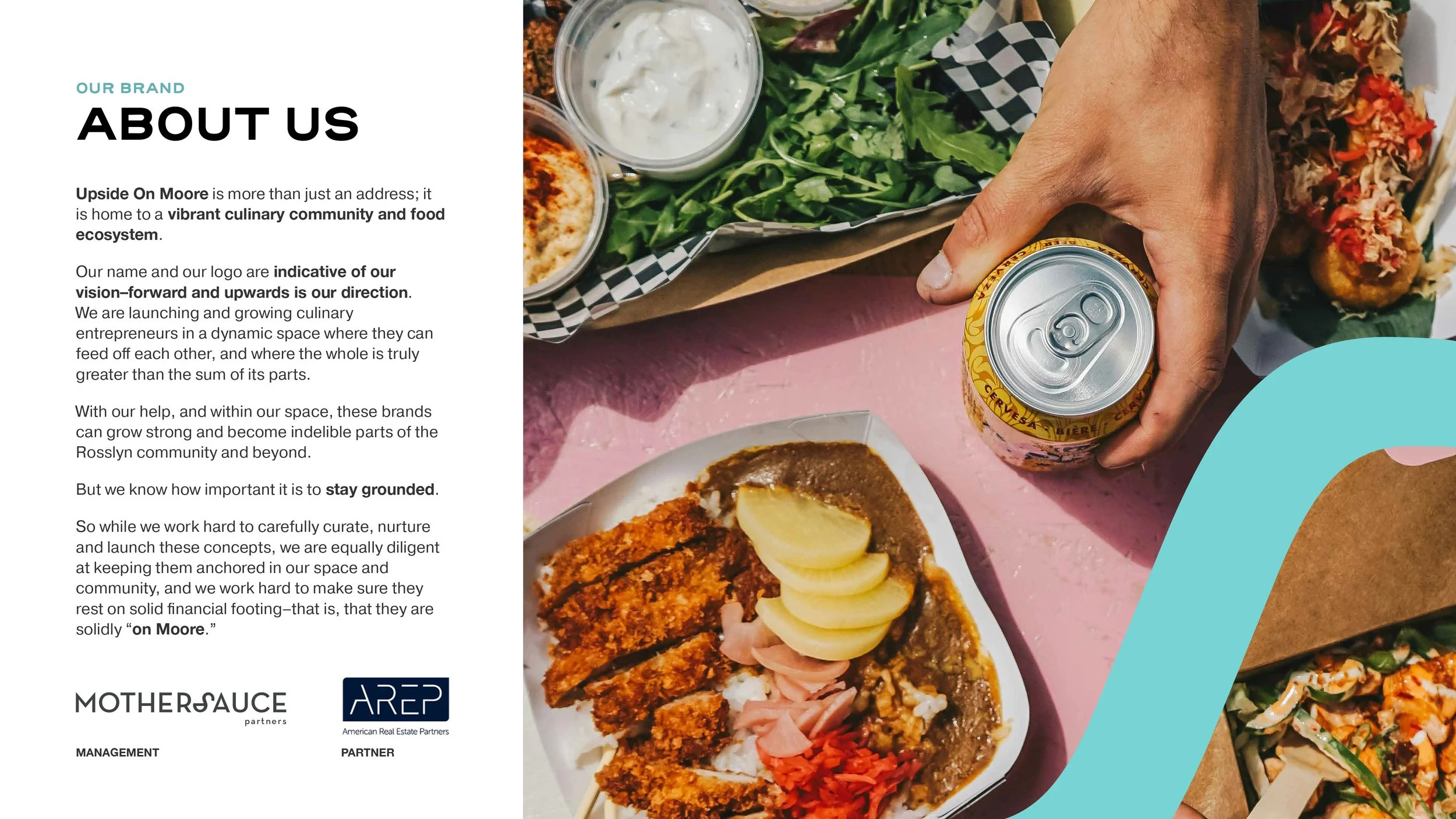 A hand holding a canned beverage over a table with various foods including a salad with dressing, a plate of fried fish with lemon slices, and a pizza with vegetables. The table is pink with a blue decorative element.