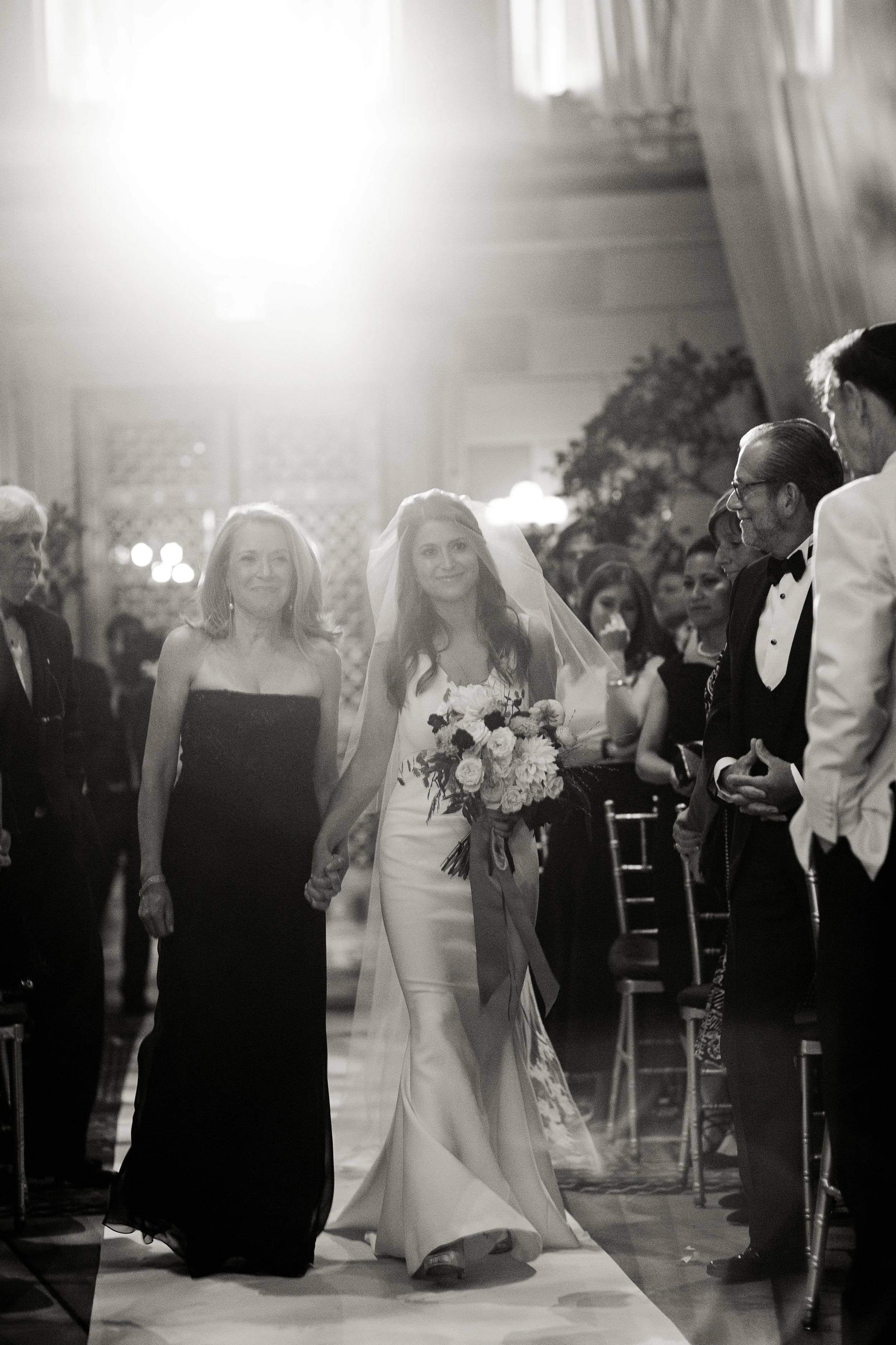 Alix's mother walking her down the aisle during her ceremony.
