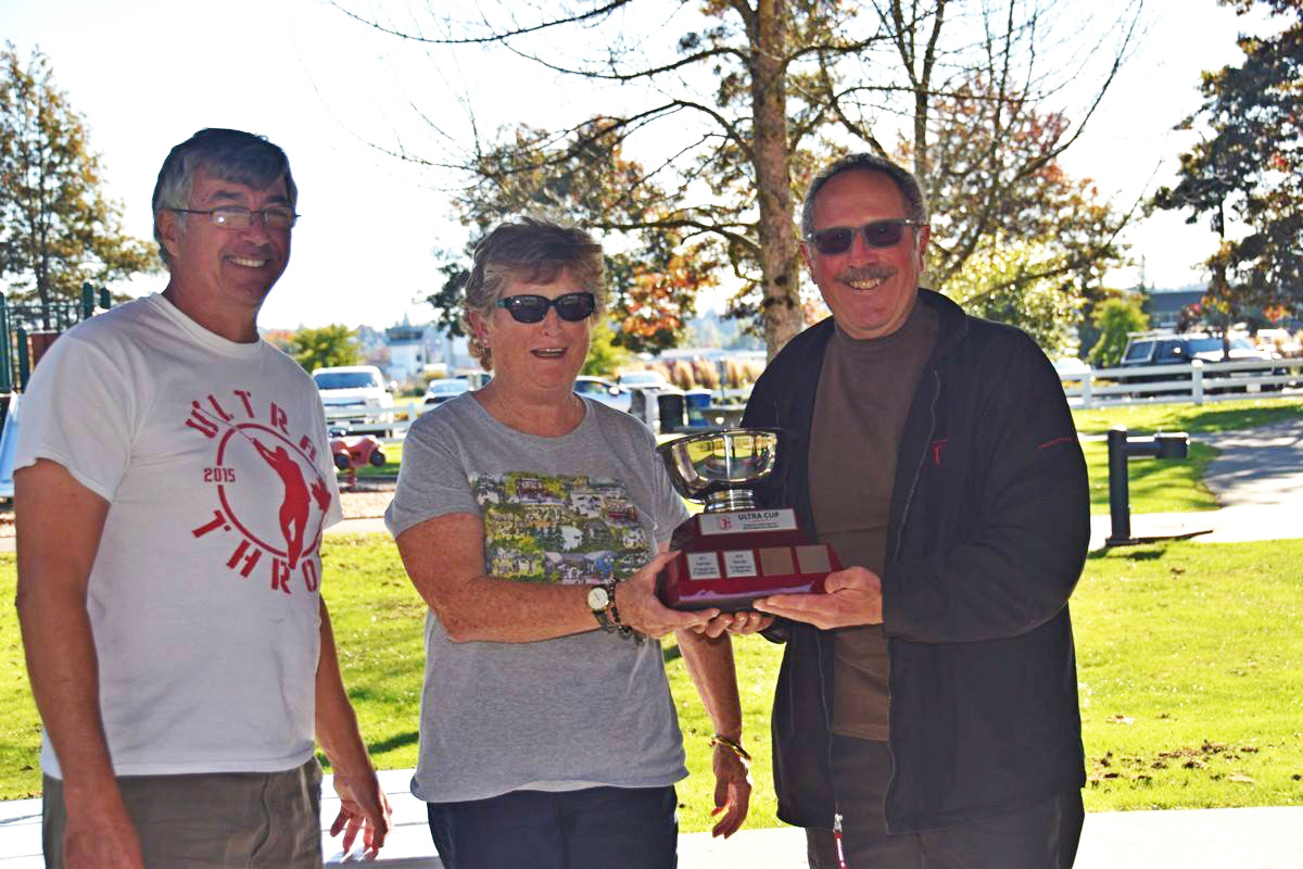 Last year’s recipient, Rose Hare presents David Ulis with the Ultra Cup. Left is Club president, Dave McDonald. (Photo: Owen Wong)