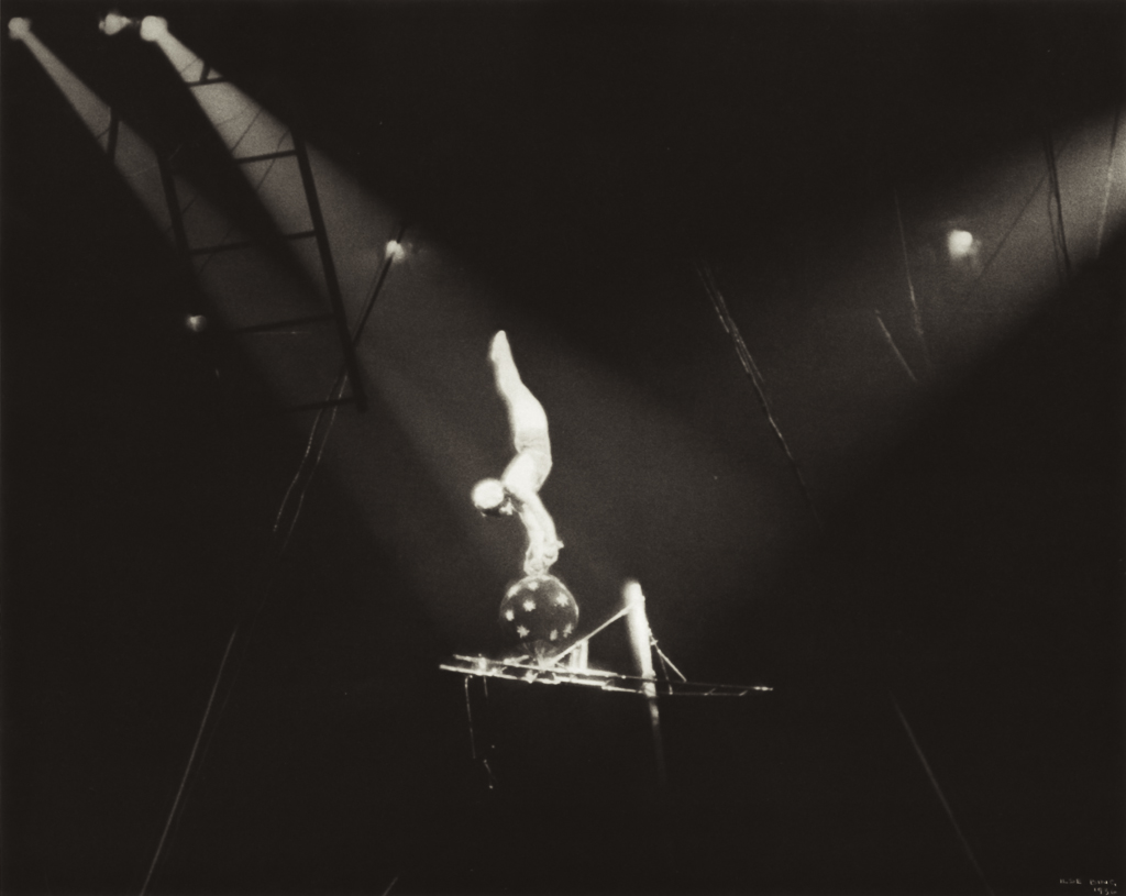 ILSE BING, Circus Acrobat on Black Ball, New York, 1936