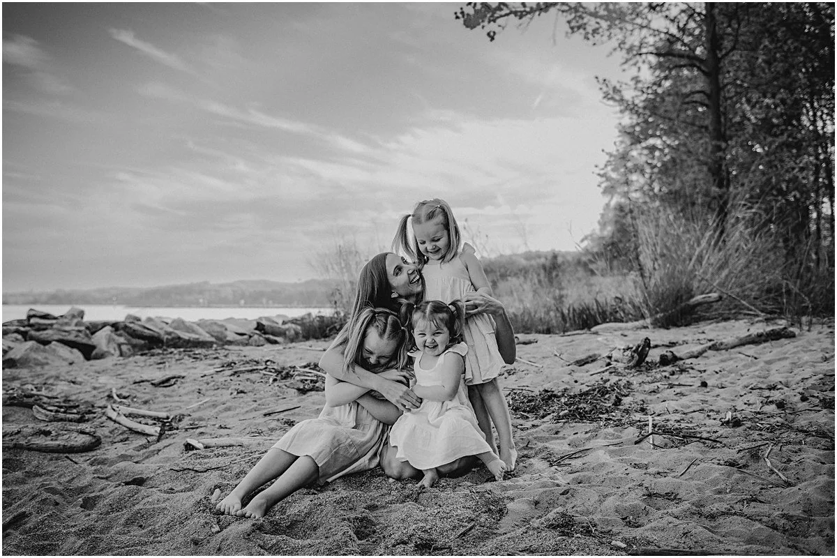 Black and white photo of the Caton girls all laughing together on the lake shore