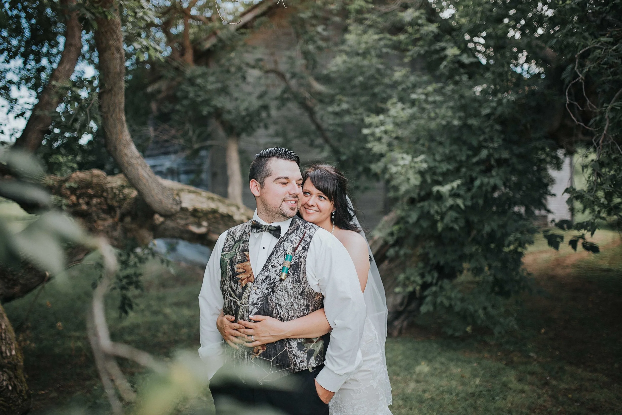 Joe + Tami are a fun-loving couple who wanted their wedding day to be laid-back + lighthearted. That is what they got with the beautiful hillside with a flowing river in the backdrop of their ceremony. They incorporated some kick ass camouflage vests, being as Joe is an outdoorsman and the bridesmaids followed suit with their earthy gowns. Tami was inspired with this look and beautifully crafted her centre pieces and her wedding decor. Her personal touches made this day look sensational. 