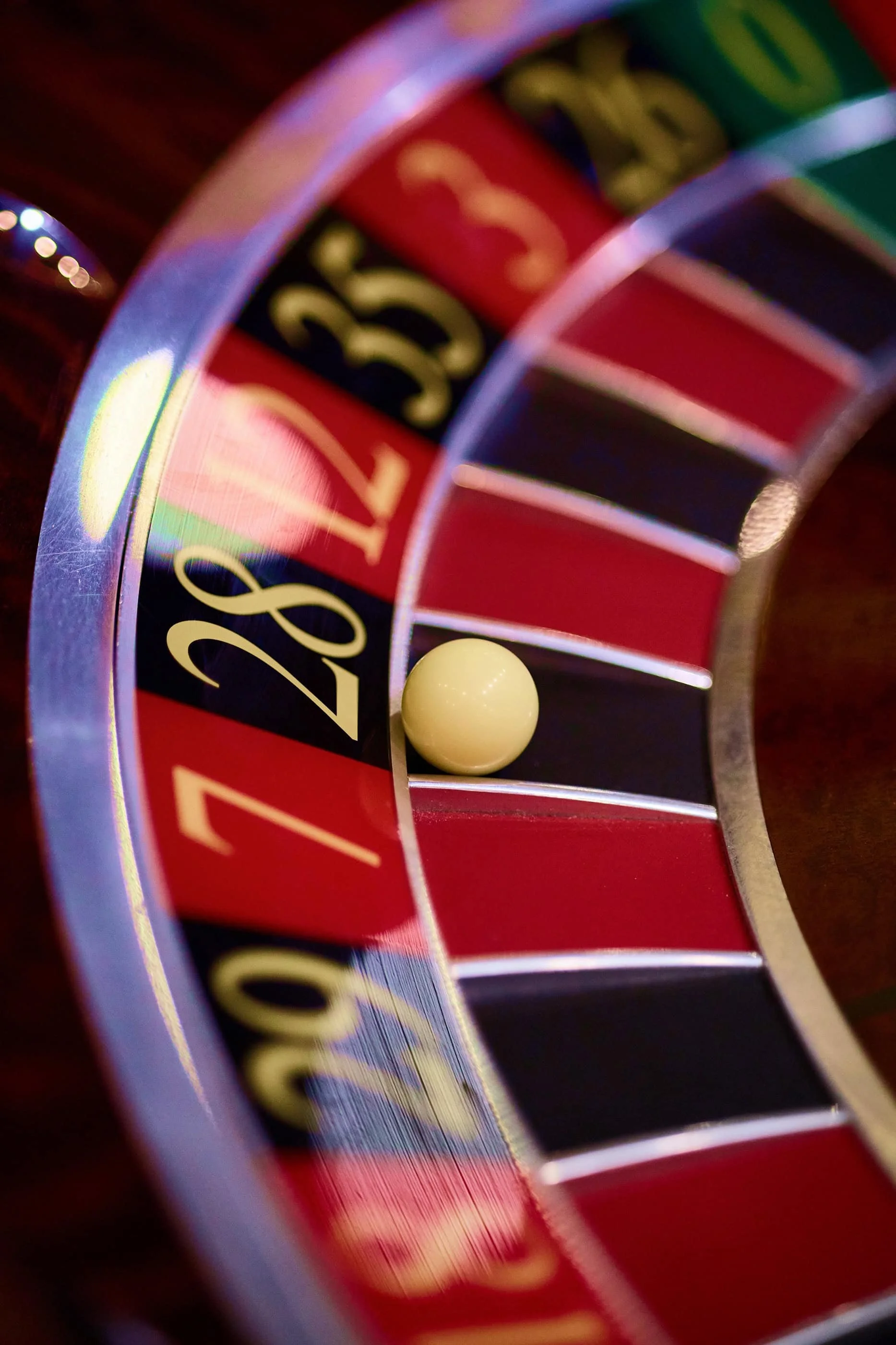 Close up of a roulette table with white ball on 28.