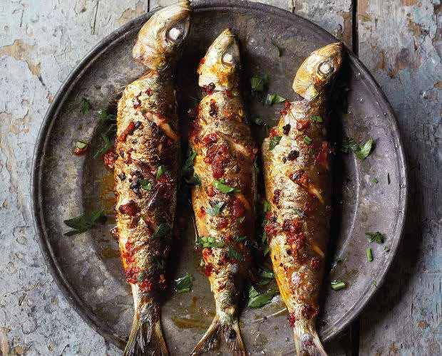 delicious barbecued harissa sardines on a place. this is a healthy option for your next barbecue