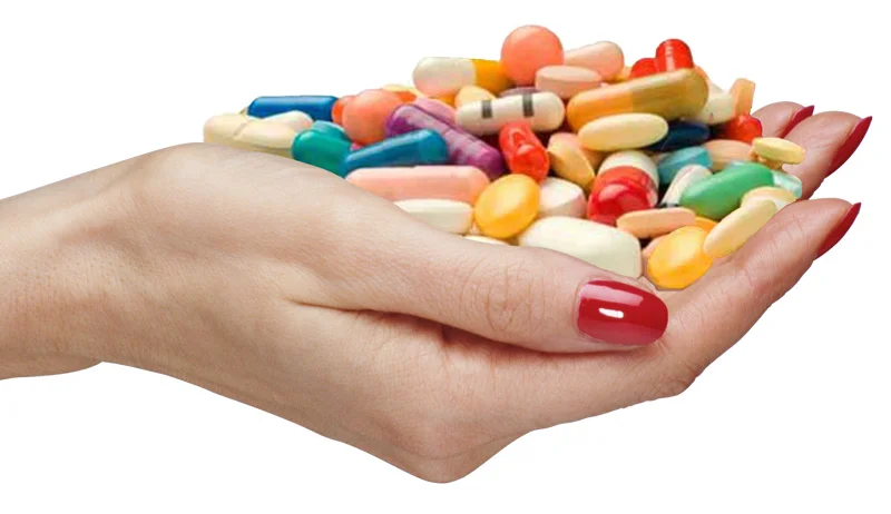 a hand holding supplement pills