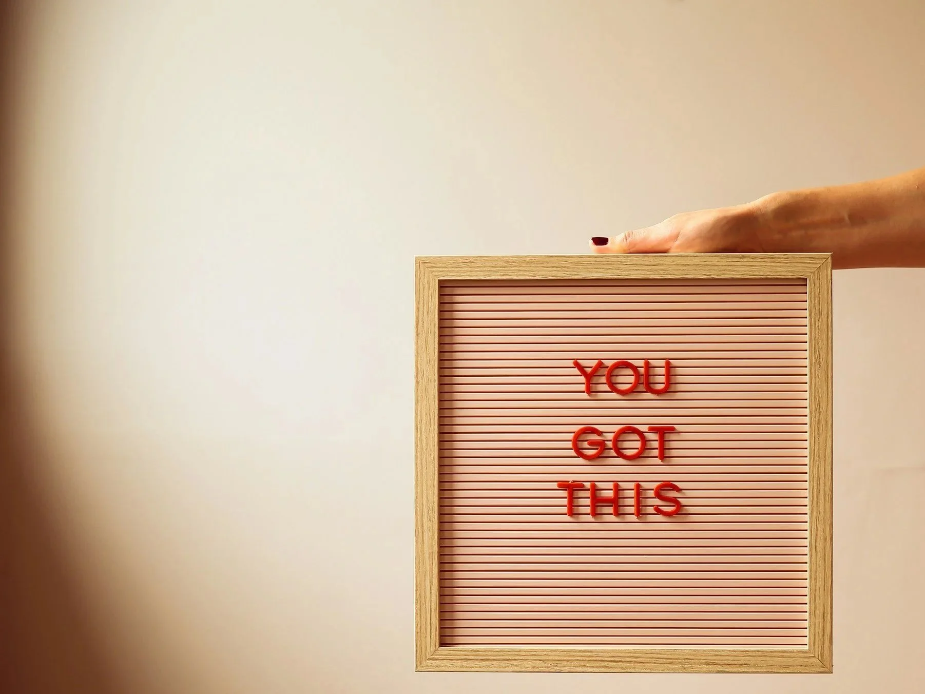 Colorful hot air balloons floating in a clear blue sky, with one large striped balloon dominating the foreground and several smaller balloons in the background.