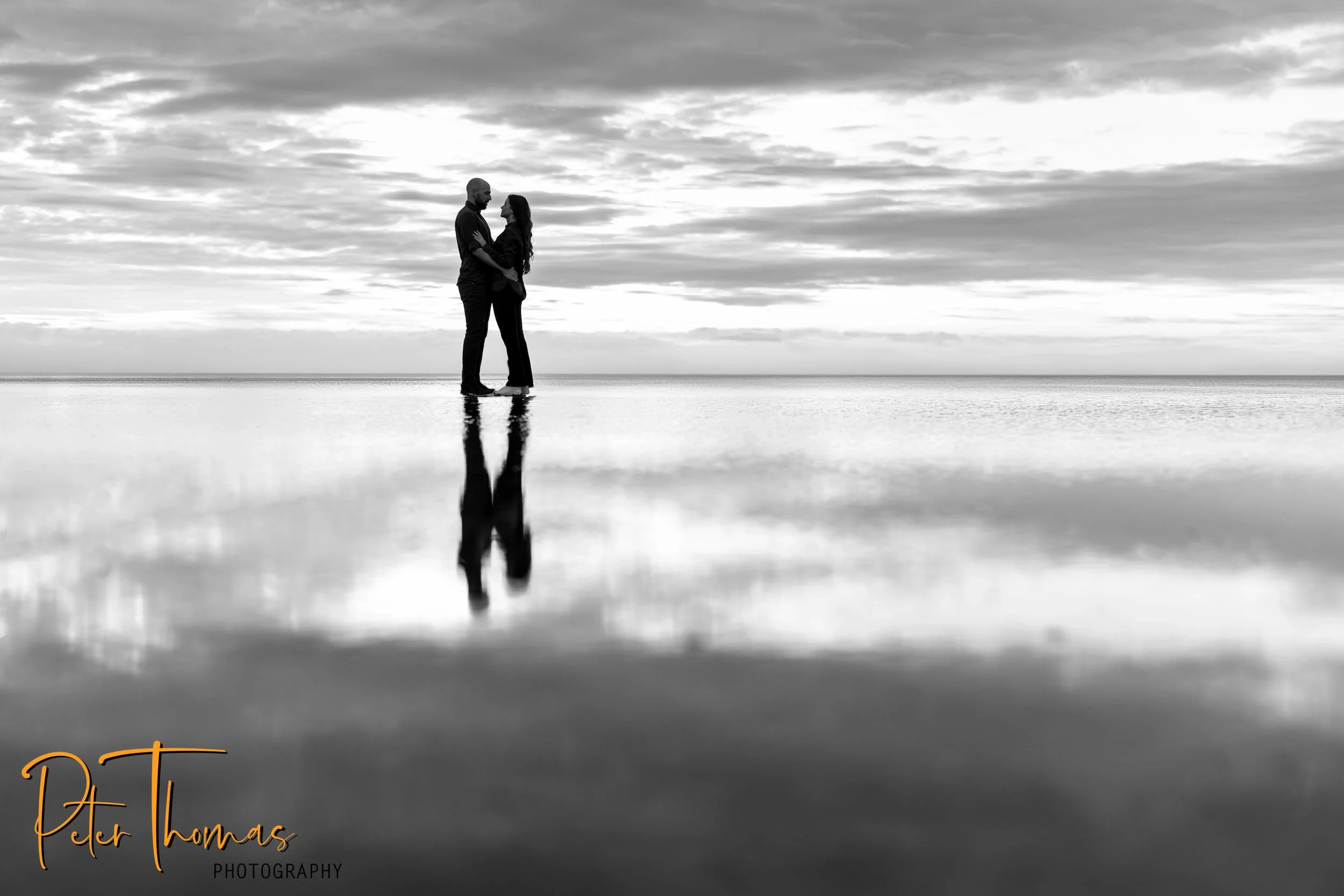 The engaged people are standing on the beach at Seasalter, near Whitstable Kent.