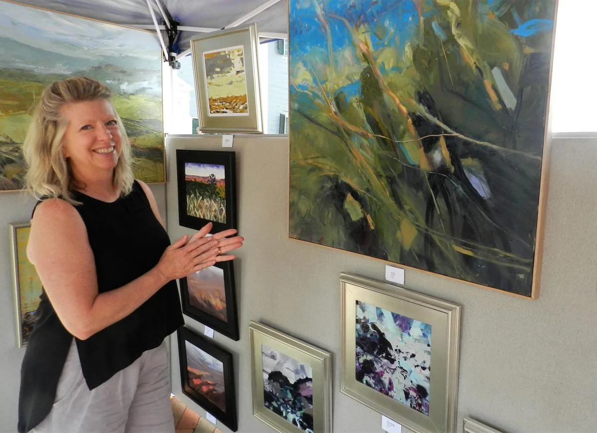 Sally Veach, of Woodstock, talks about her painting titled “The Tangle,” which illustrates the experience of walking through forest foliage. Inspired by local landscapes, she said her work focuses on color and gestural marks. Josette Keelor/Daily