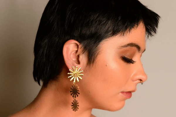 A woman wearing a geometric sun shaped earring