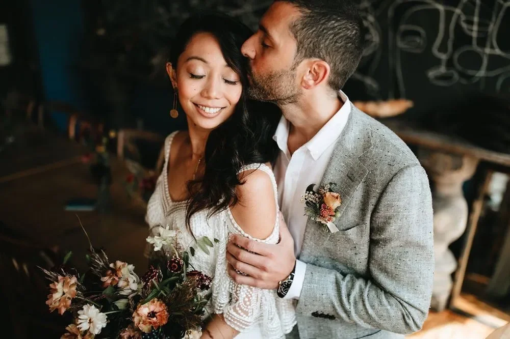 Groom embracing bride in a beaded wedding gown during their intimate celebration in Baltimore Maryland