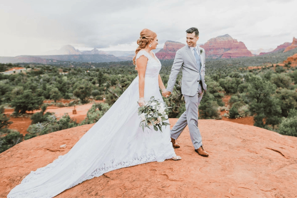 The bride and groom smiling while holding hands