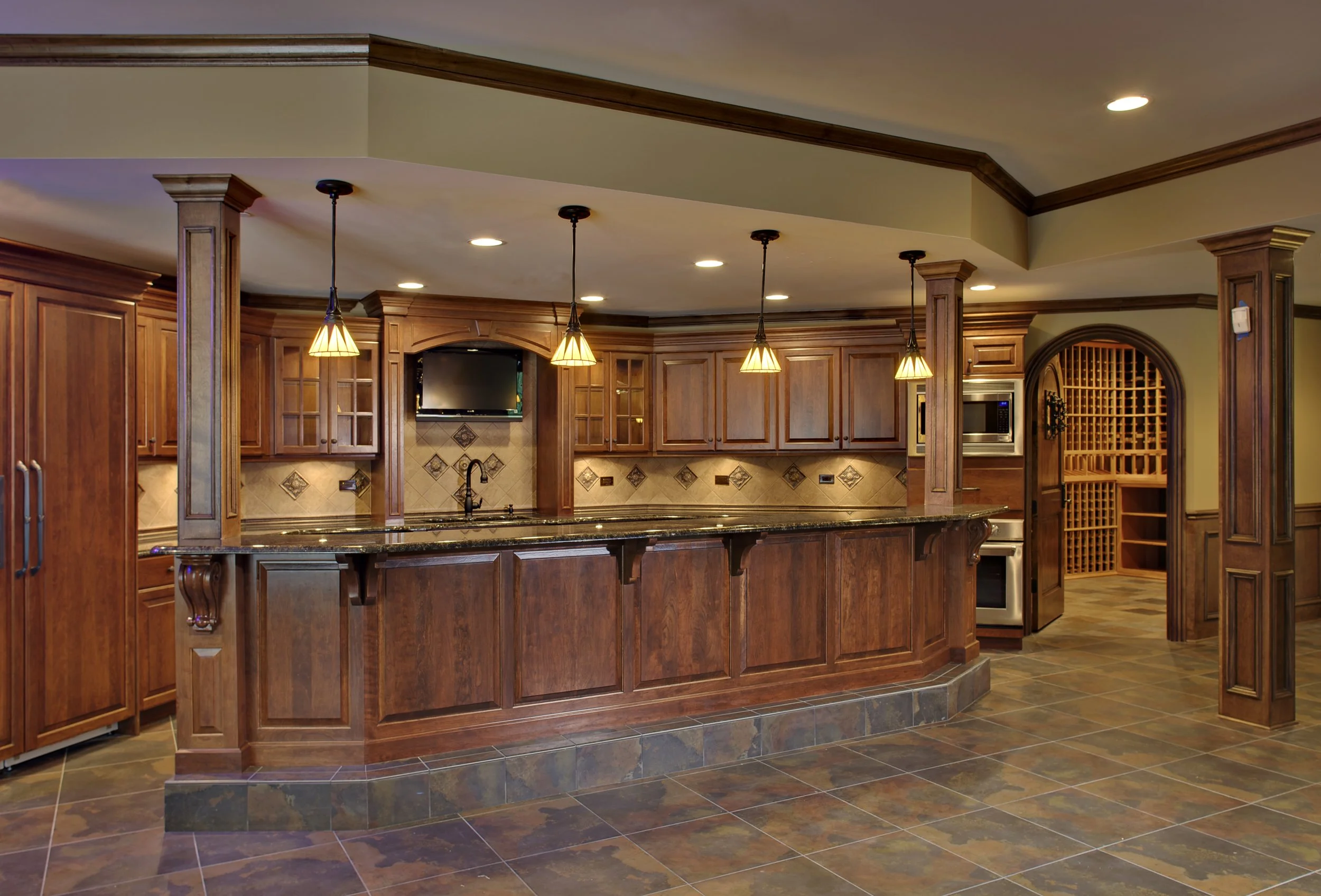 Custom Basement Bar in Geneva IL 60134. Custom Wine Cellar with arched Wooden Door by Southampton Builders LLC