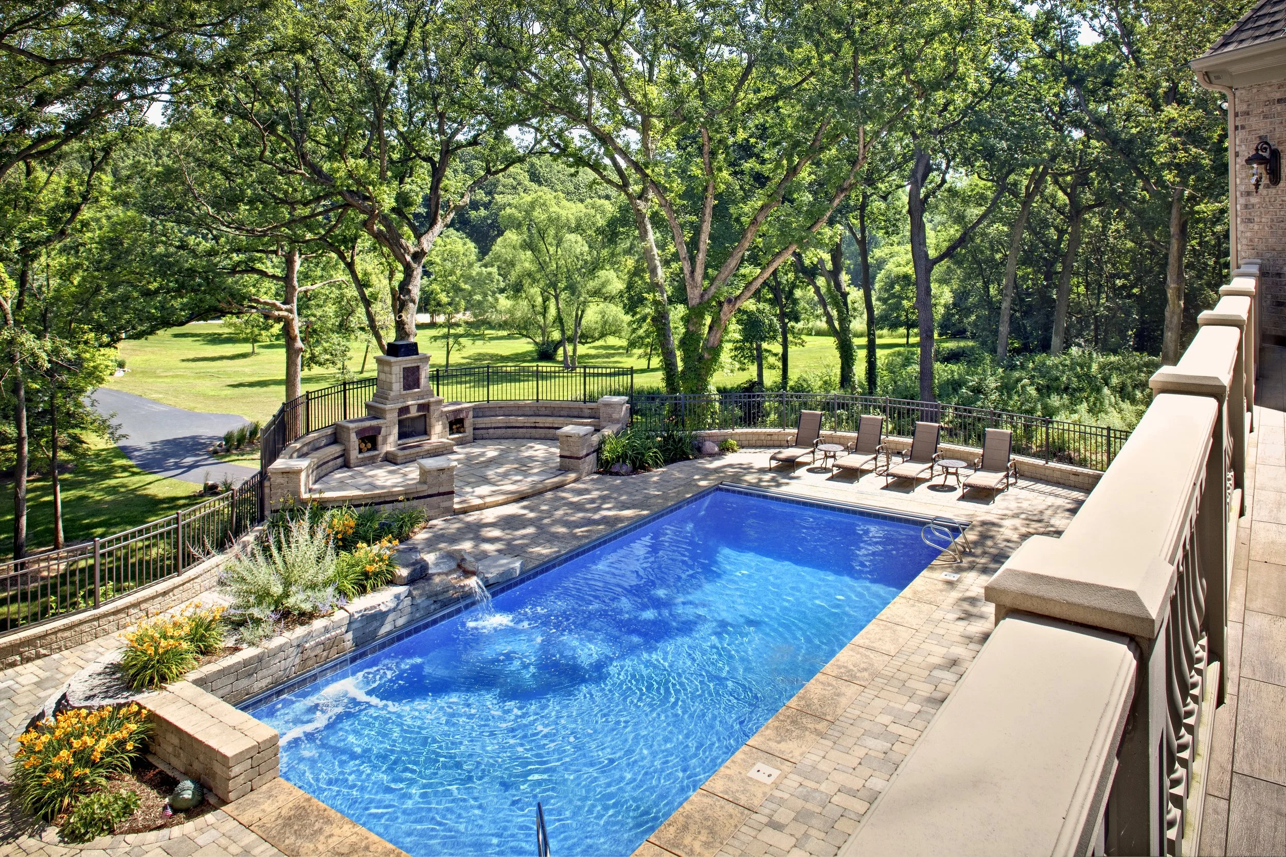 Pool in the Oak Trees & Outdoor Unilock Fireplace.  Custom Pool by Southampton in Geneva Illinois 60134