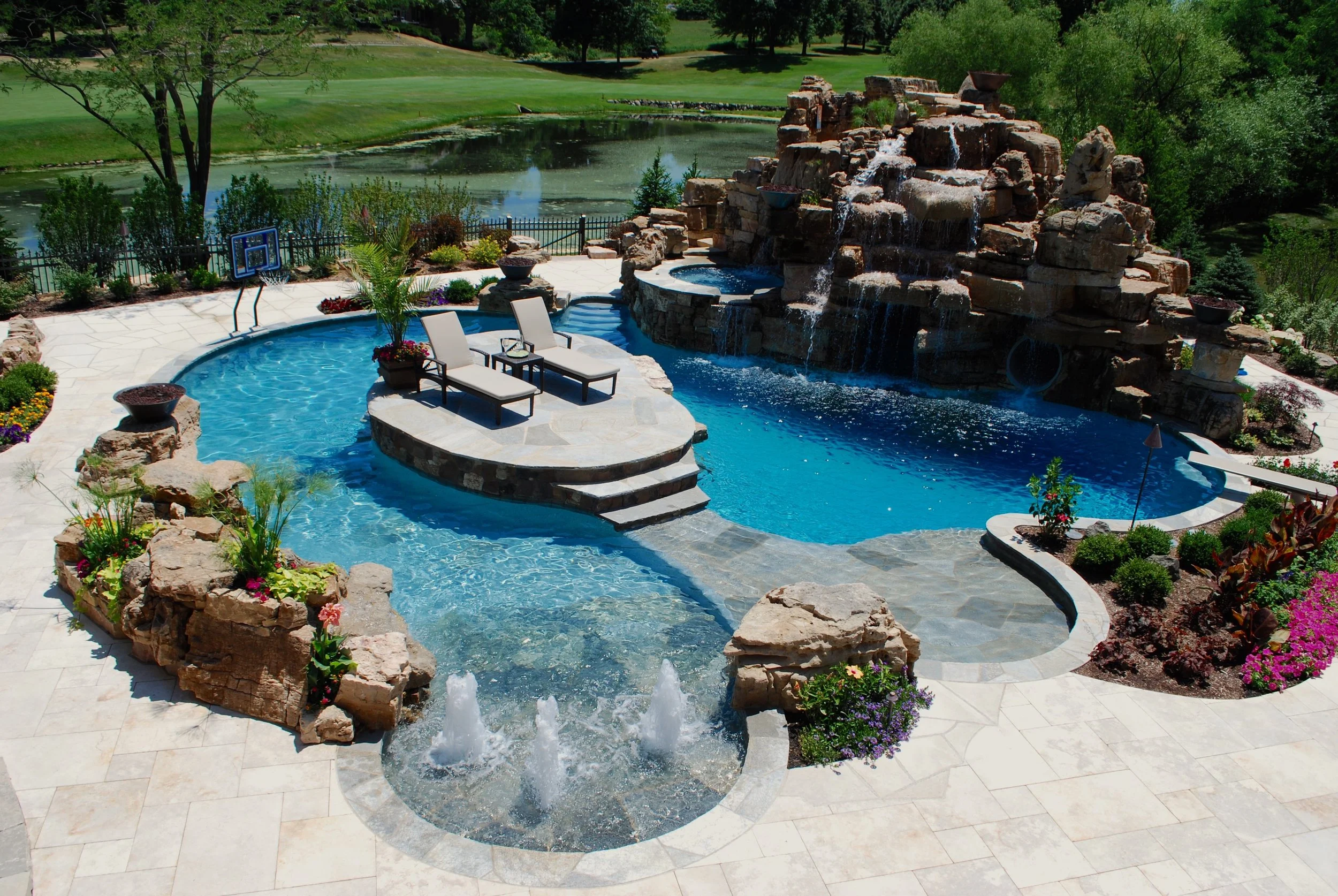 Custom Pool with Island, Slide, Rock Mountain, Diving Board, Hot Tub & Grotto.  By Southampton Builders LLC 