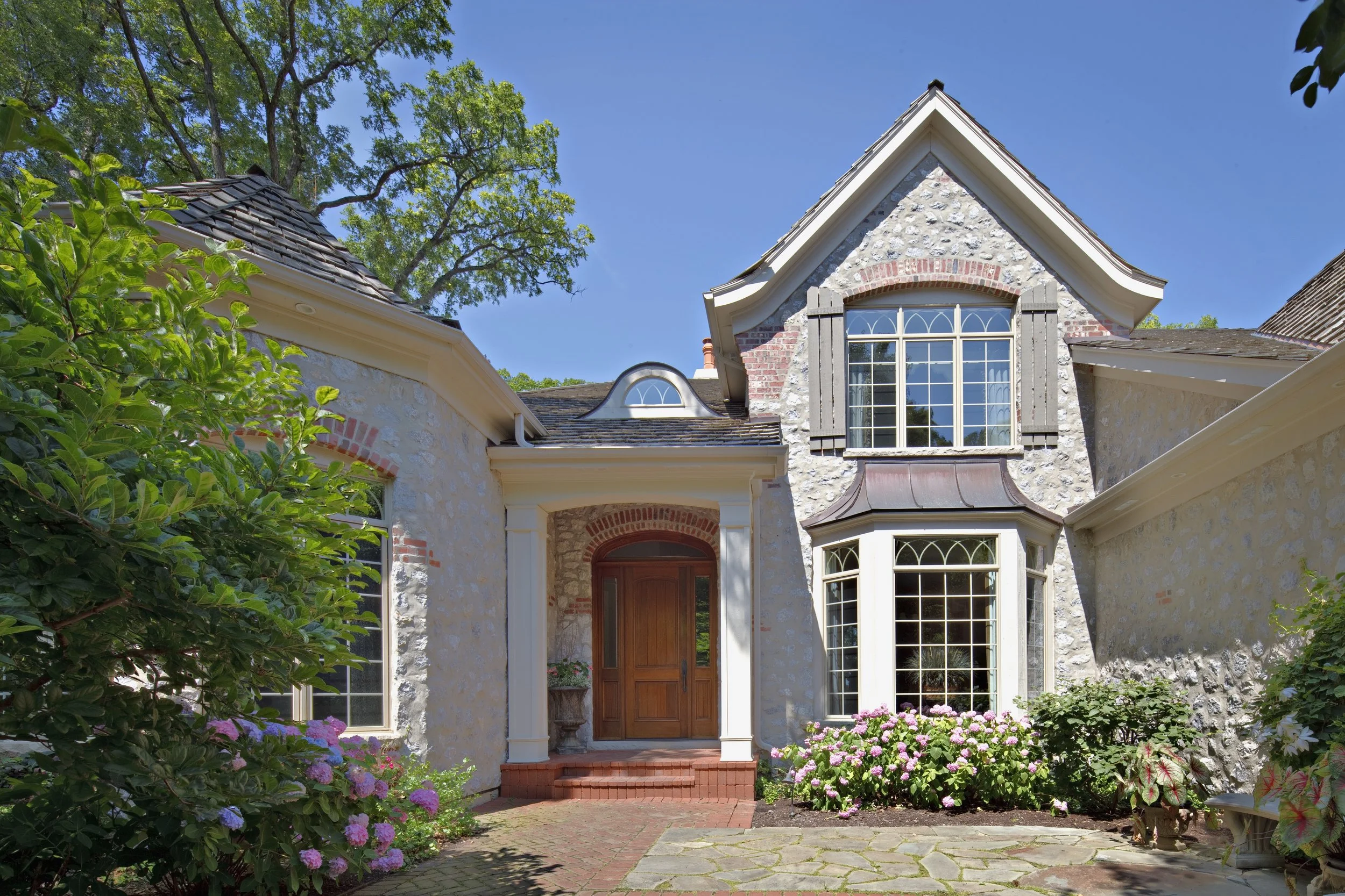 CUSTOM STONE FACADE WITH GOTHIC GRILLS IN WINDOWS
