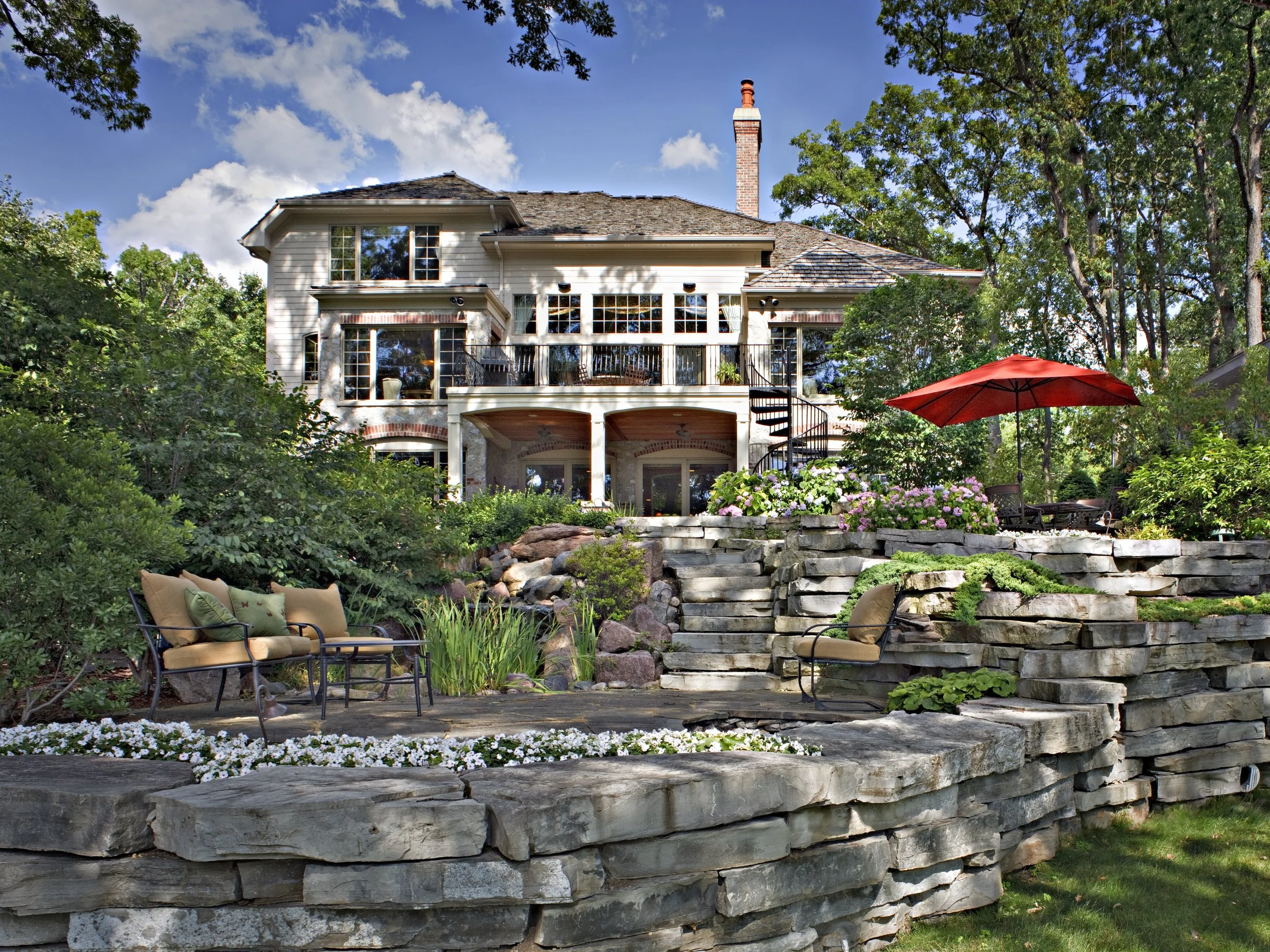 Extensive Bluestone Backyard Terracing to Make Different Levels and a Pond Running to Multiple Levels