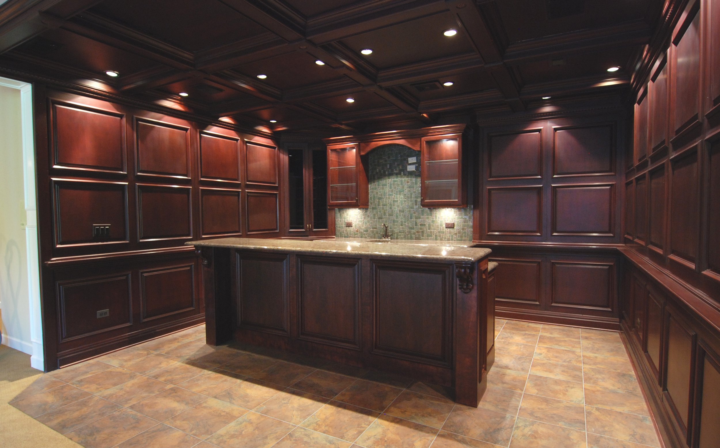 STATELY BASEMENT BAR WITH DEEP CHERRY STAIN AND WOOD PANELING WITH LABRADOR GRANITE IN BARRINGTON IL.