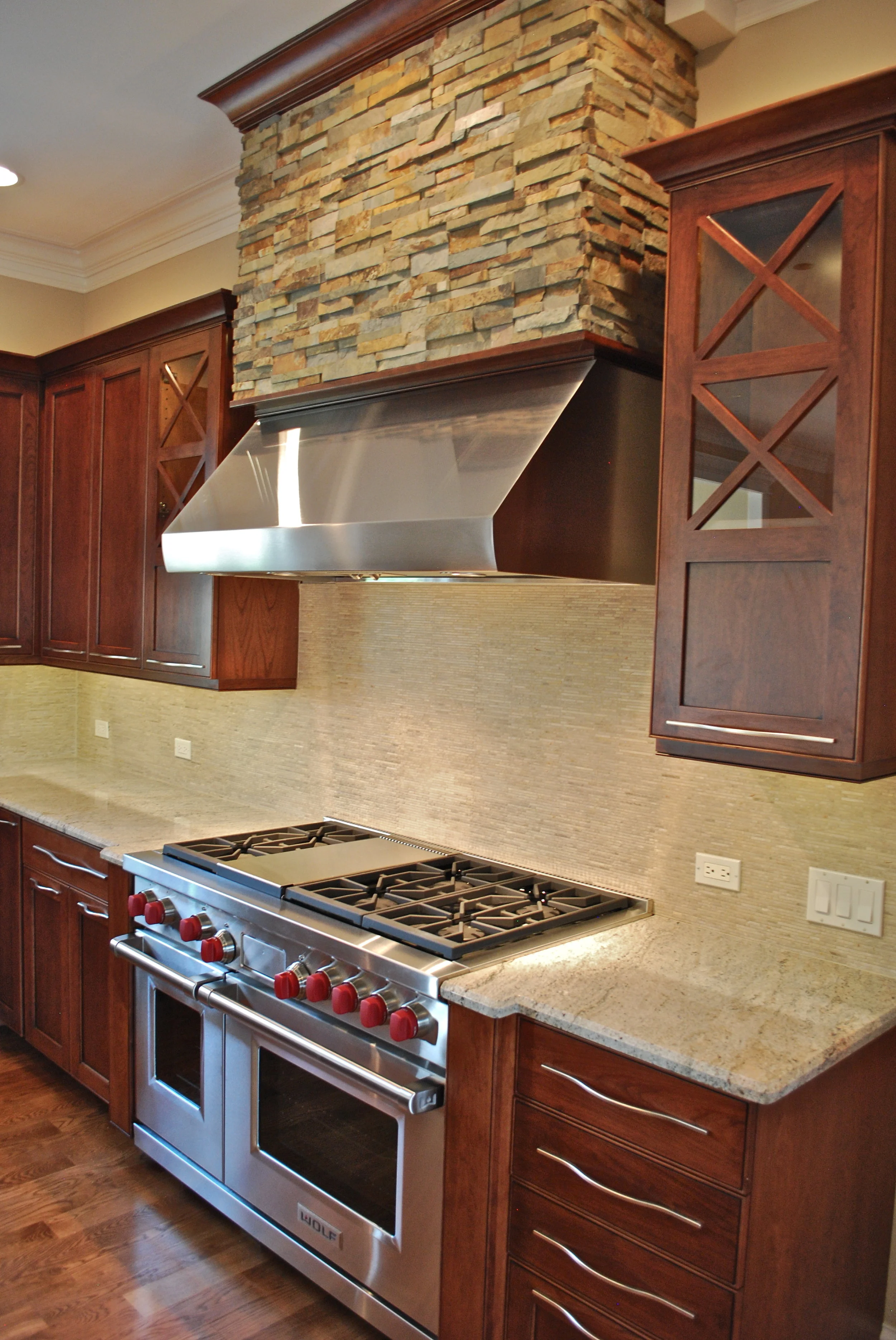 STACKED STONE KITCHEN HOOD WITH STAINLESS VENTILATION IN THIS WHEATON CUSTOM HOME