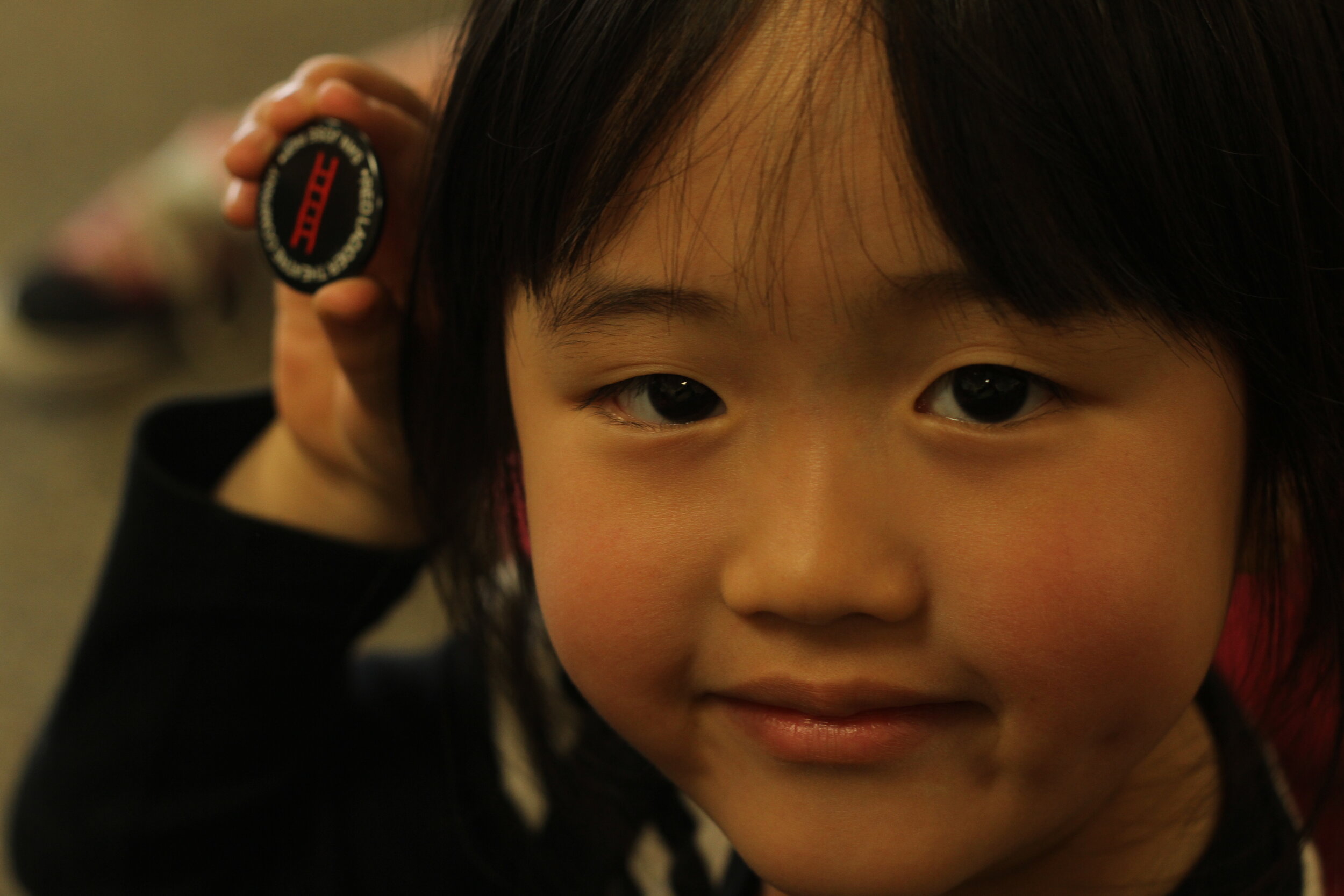 Girl Holding Red Ladder Button.JPG