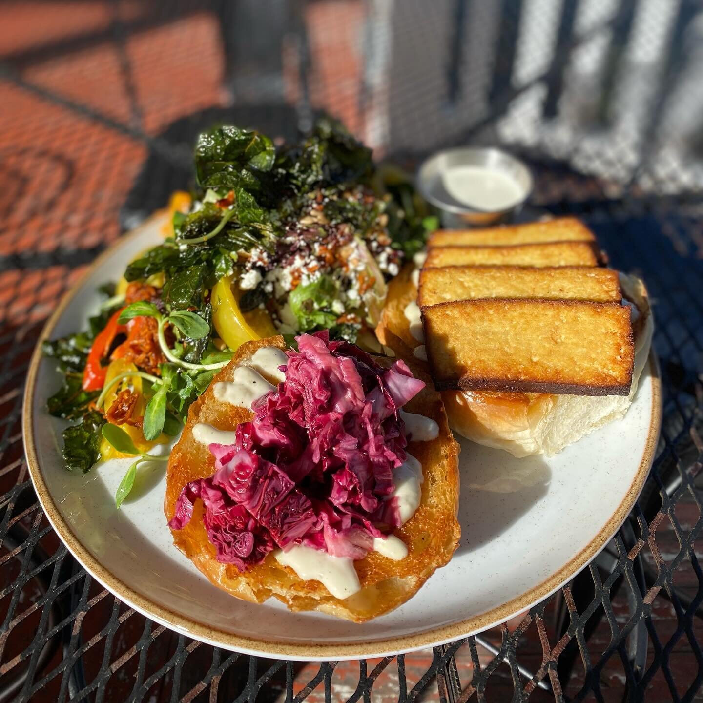 Smoked and fried tofu sandwich on a @betweenthetreesbread bun with pickled radicchio and a caper &amp; nasturtium aioli! Pictured here with our seasonal salad on the side. Y&rsquo;all come and get it.