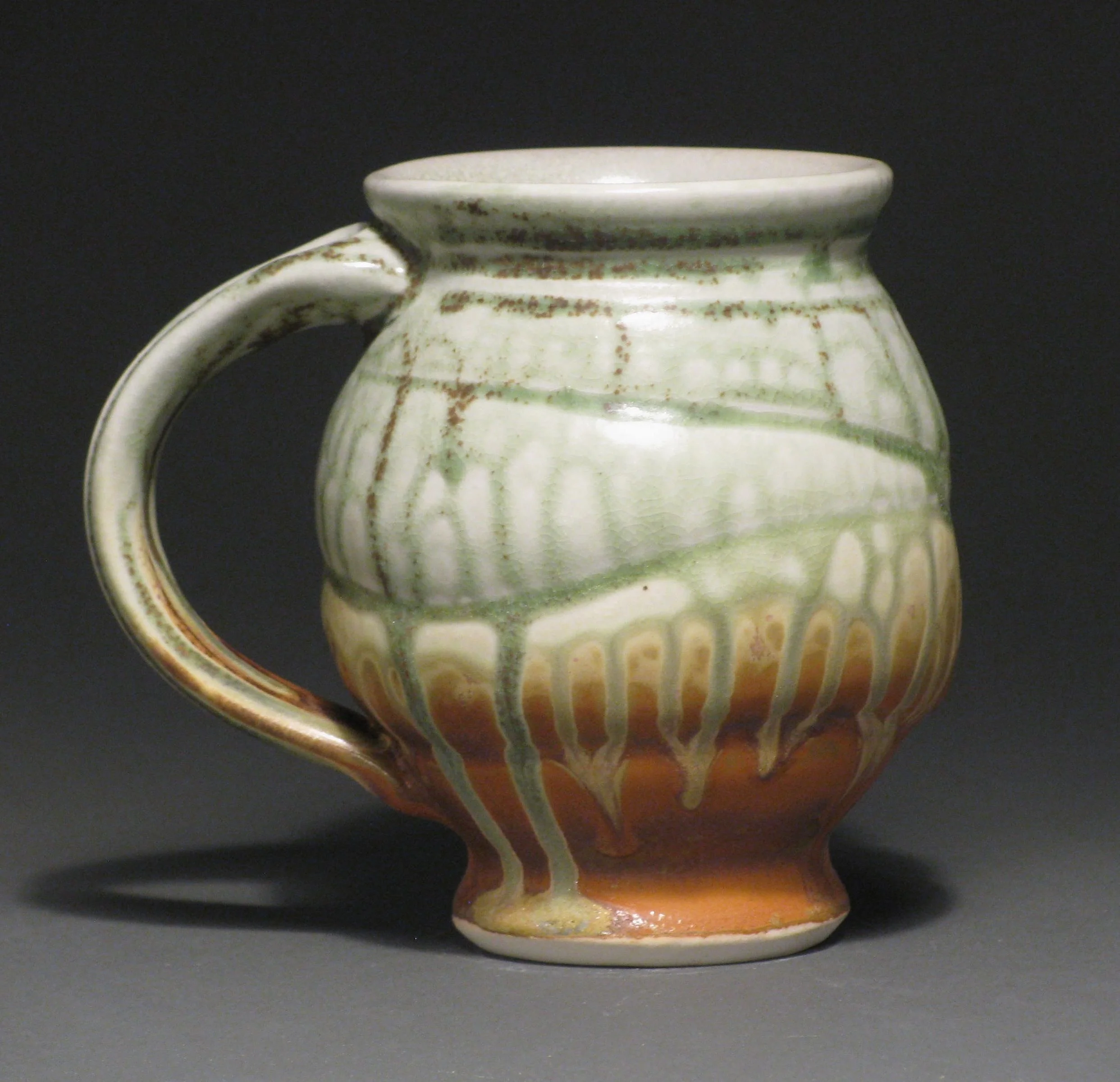 Round bellied mug 5" tall Glazes: green ash and matte rust