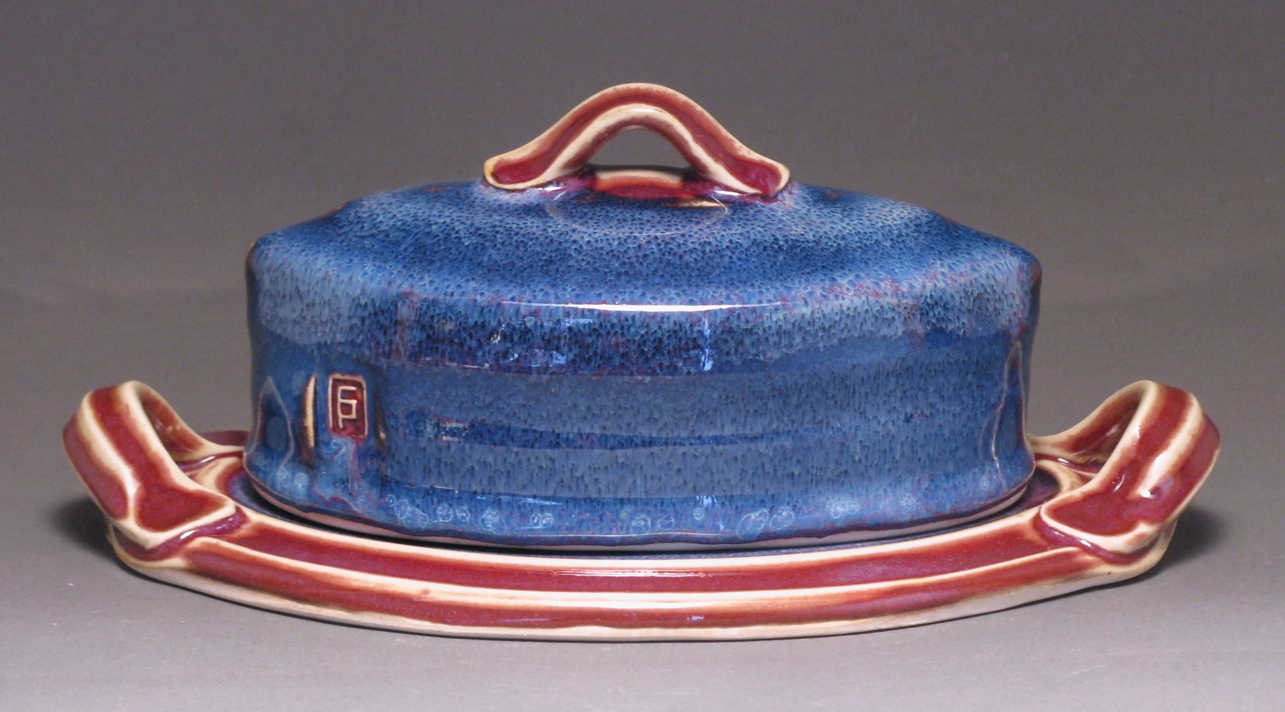 Oval butter dish 8.5" long Glazes: purple haze and copper red