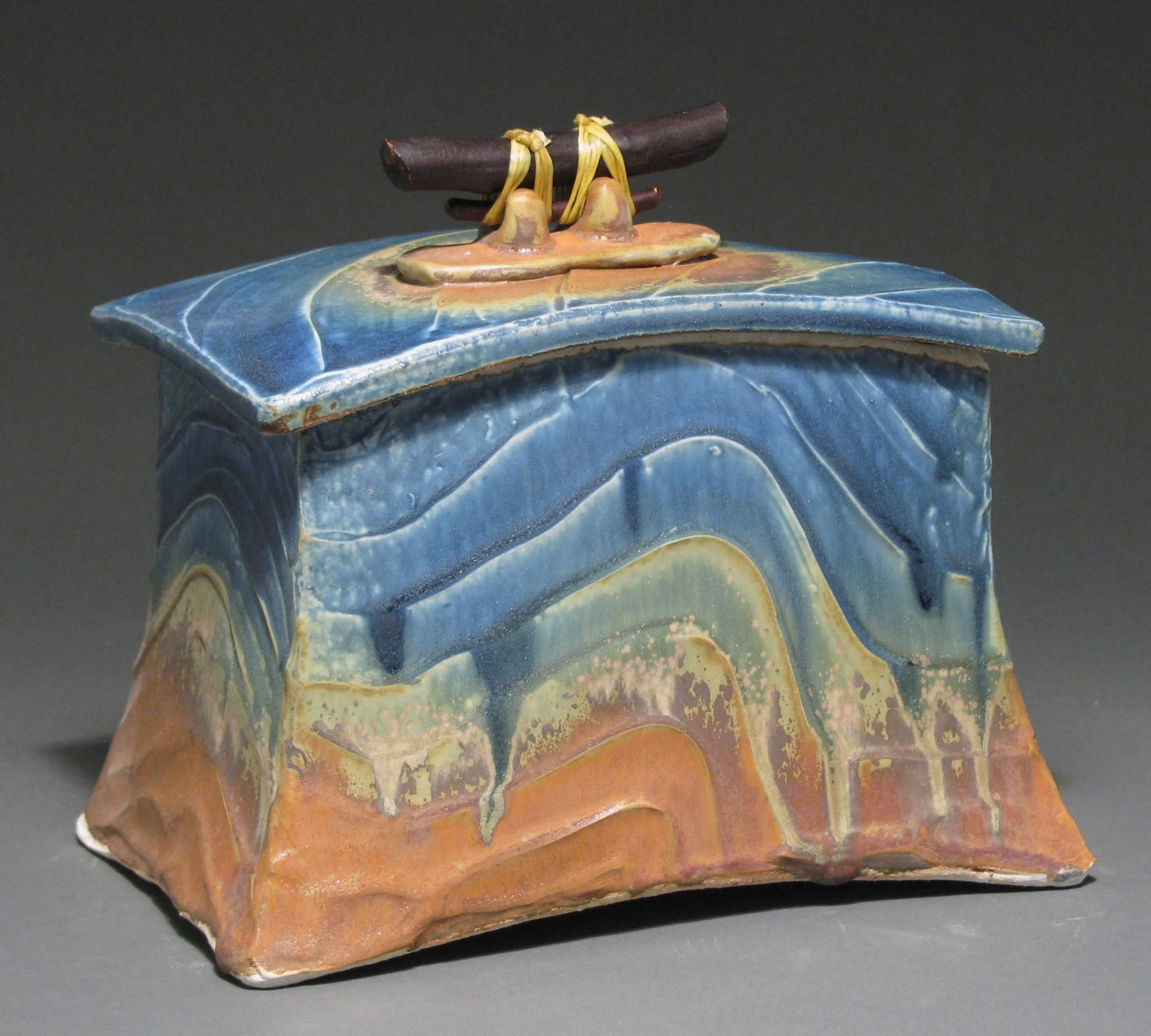 Lidded box 7" tall by 7 3/4" long by 5 1/4" wide Glazes: mixed blue and matte rust