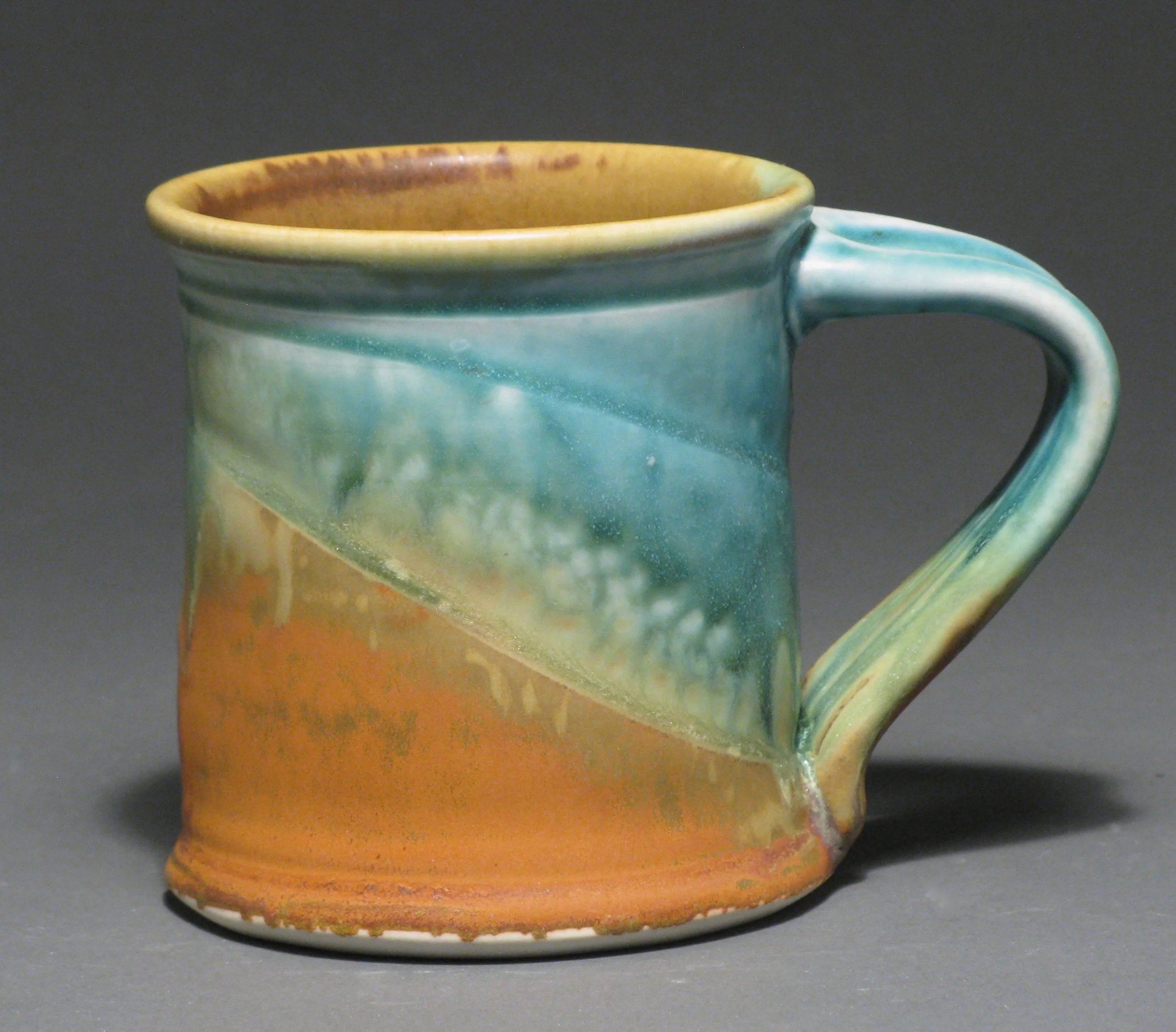 Cylindrical mug 4” tall Glazes: Matte turquoise and matte rust