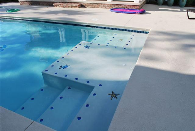 Overview of multiple small mosaic installations in the shallow end of the pool.