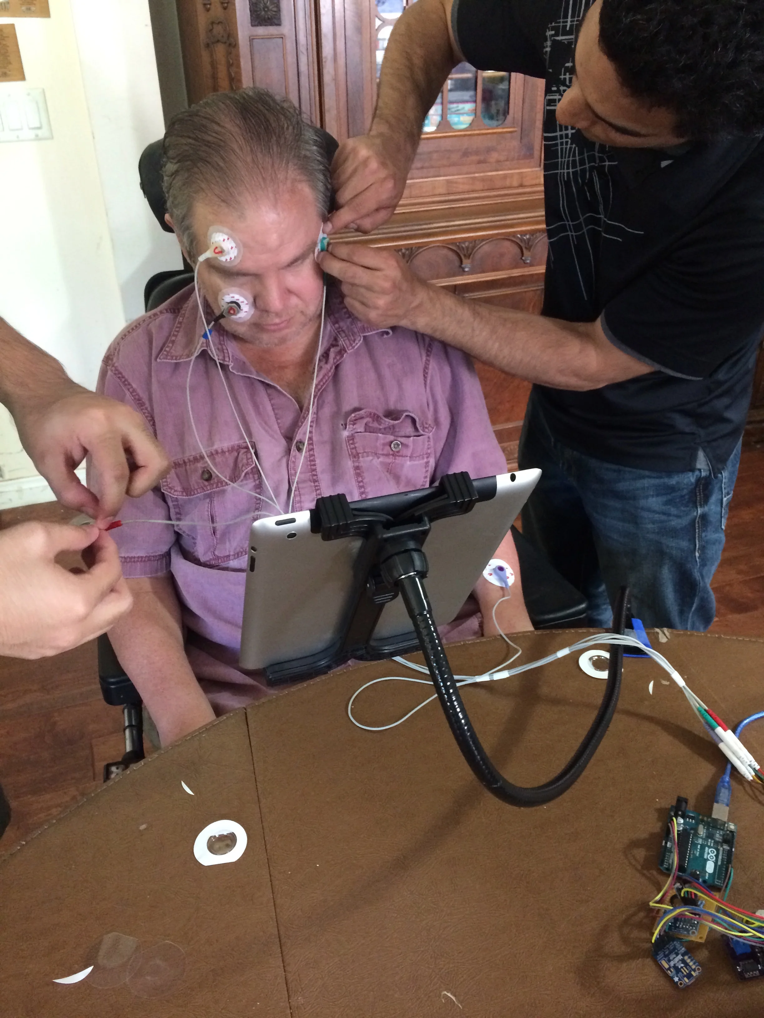 Dominic Nega (left) and Bryce O'Bard attached electrodes to James Blount to test electroocularography equipment. (Photo by Loud Owl)