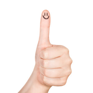 A thumbs up with a smiley face drawn on the thumb