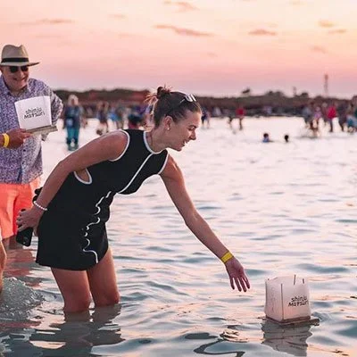 A-photo-of-a-woman-sending-her-personally-decorated-Shinju-Matsuri-paper-lantern-out-to-sea-in-Broome-at-sunset.-Print-shop-West-Perth..jpg