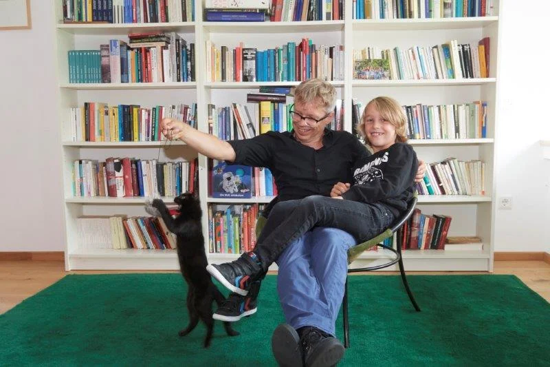 Vater, Sohn und Katze fühlen sich im 70er-Jahre-Haussichtlich wohl - die Mutter natürlich auch.