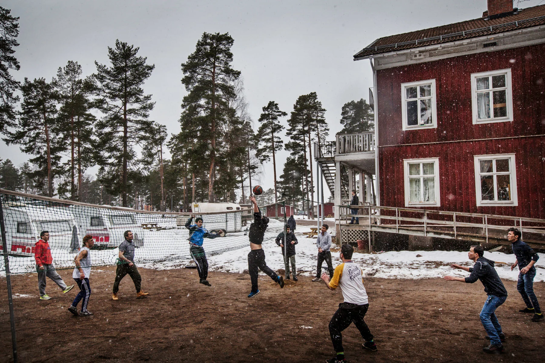  Winter keeps a firm grip of the area and light snow has begun to fall. This does not prevent a group of refugees from playing volleyball in the yard. They take every opportunity to pass the time while waiting for a decision of residence permit. In 2015 over 160 000 refugees came to Sweden and the country is now struggling with its slow bureaucratic asylum process, leaving many in frustration not knowing if they get to stay or will be sent back to the country they once fled.