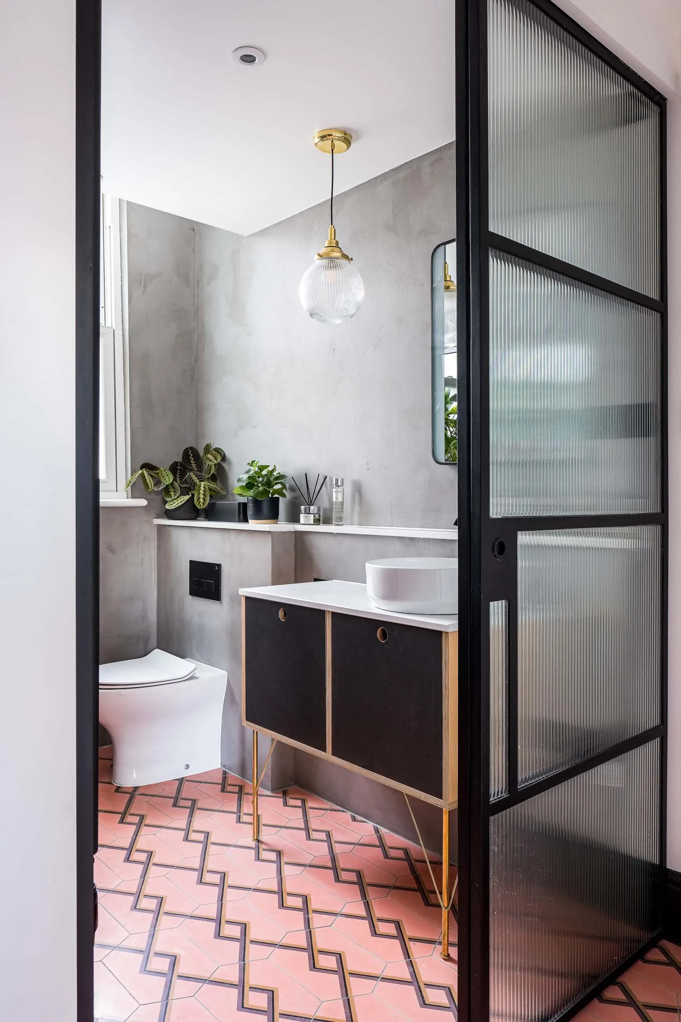 Microcement walls with bold pink tile floor